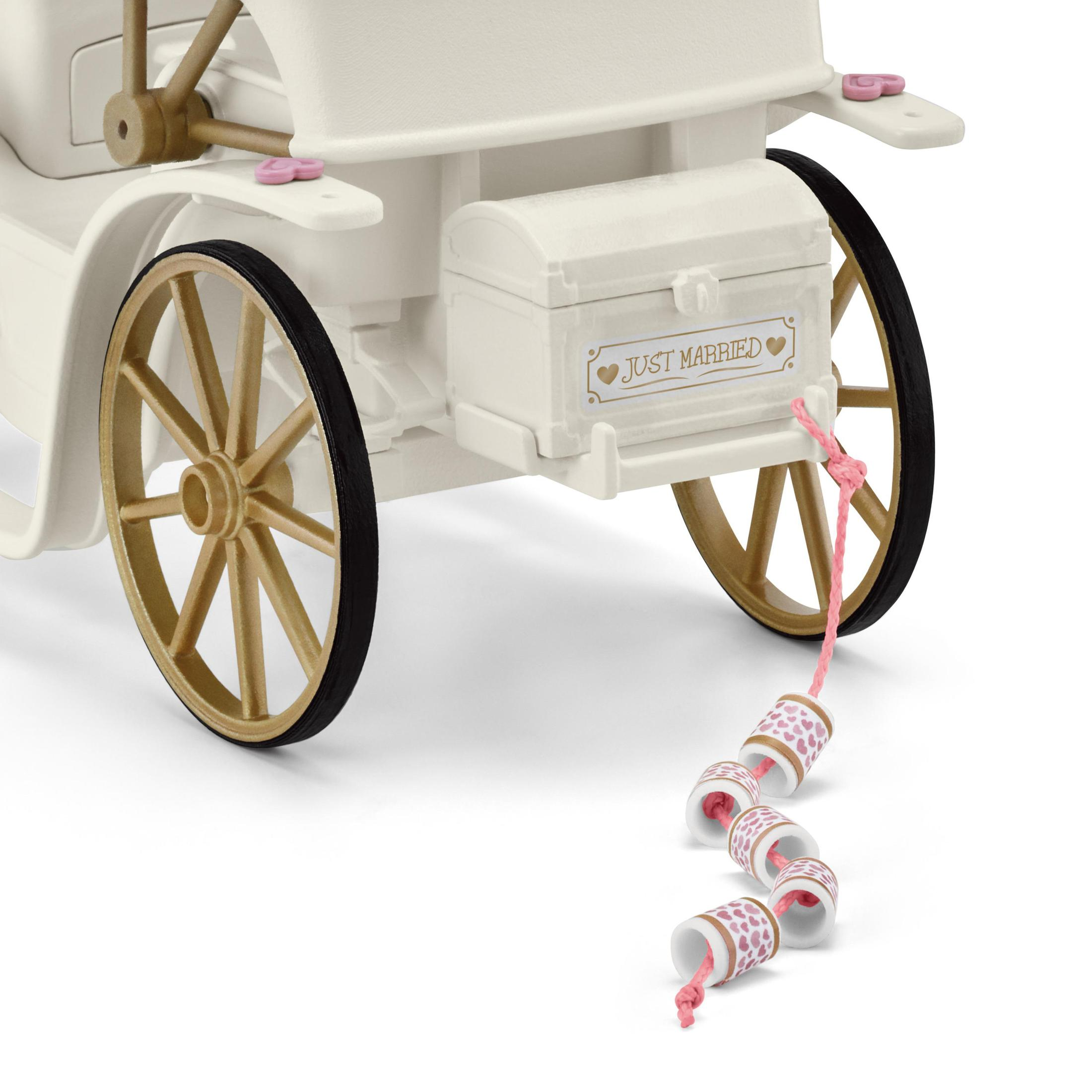 A white toy carriage with gold wheels and a box that says Just Married.