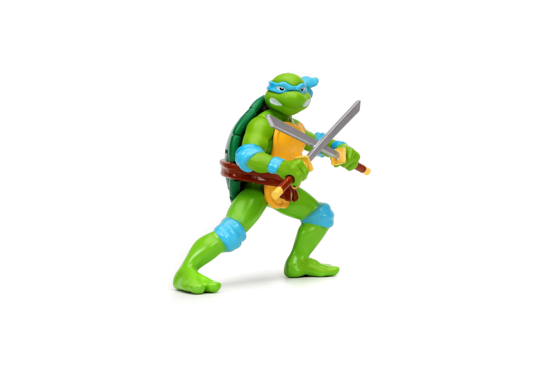 Teenage Mutant Ninja Turtle Actionfigur, grün, blaue Maske, hält zwei Schwerter. Weißer Hintergrund.