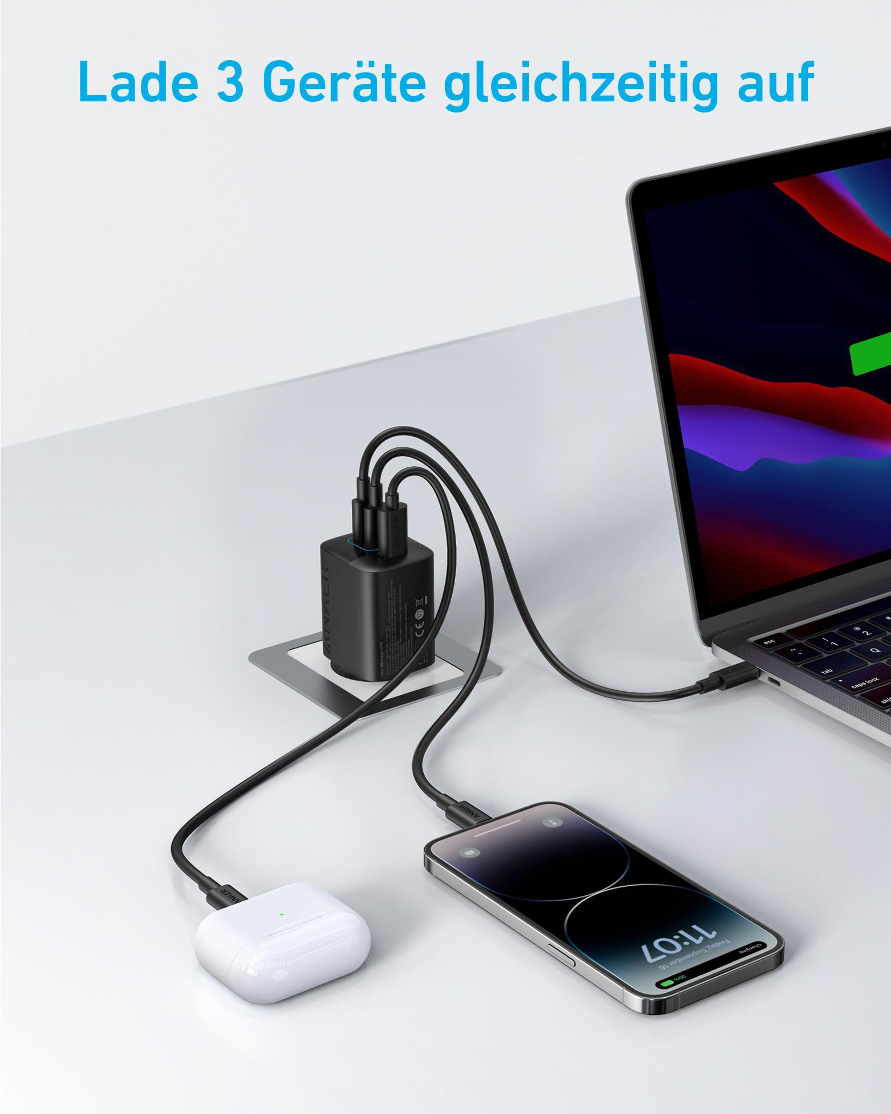 Una stazione di ricarica con telefono, auricolari e laptop collegati, su una scrivania.