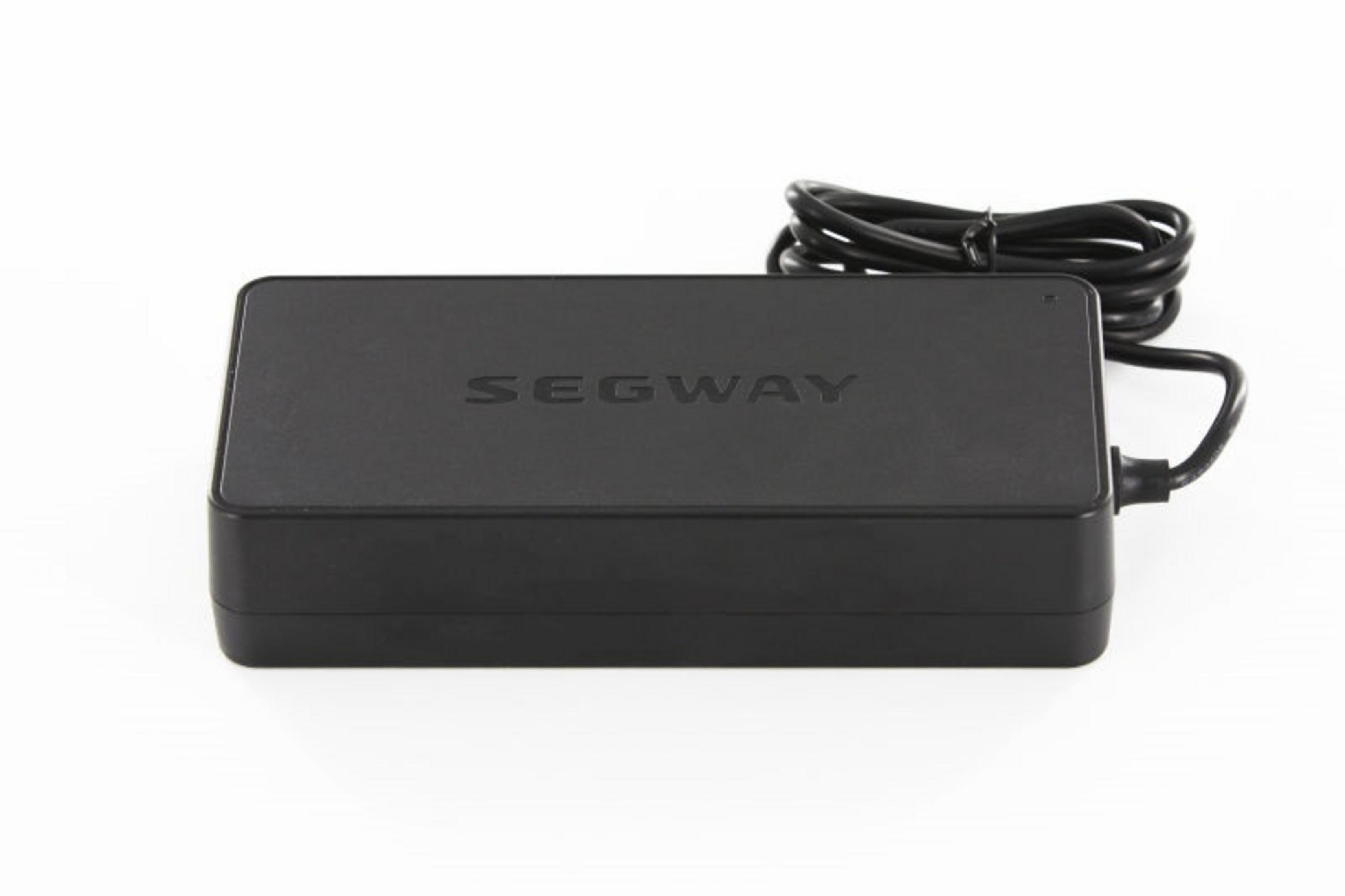 Ein schwarzes Segway-Ladegerät. Es ist eine rechteckige Box mit dem Segway-Logo darauf.