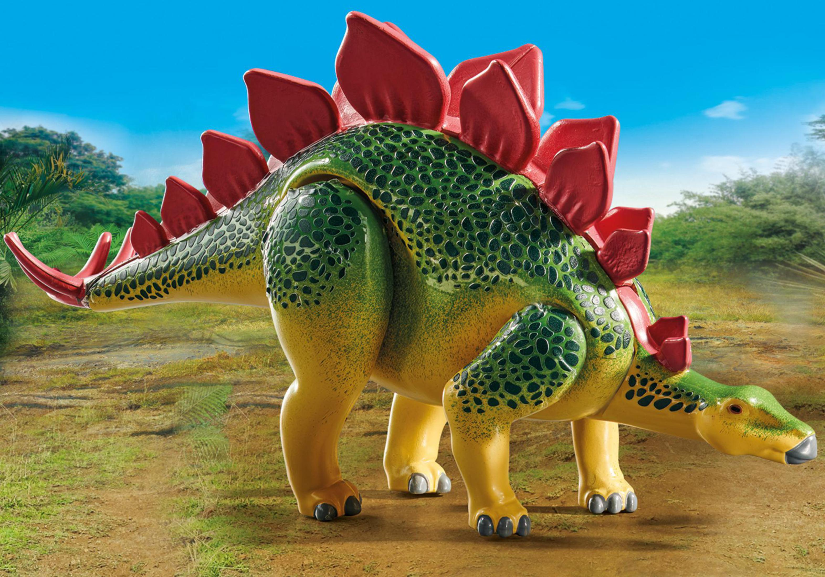 Una figura di dinosauro Playmobil, uno Stegosaurus, in piedi in un ambiente naturale all'aperto.