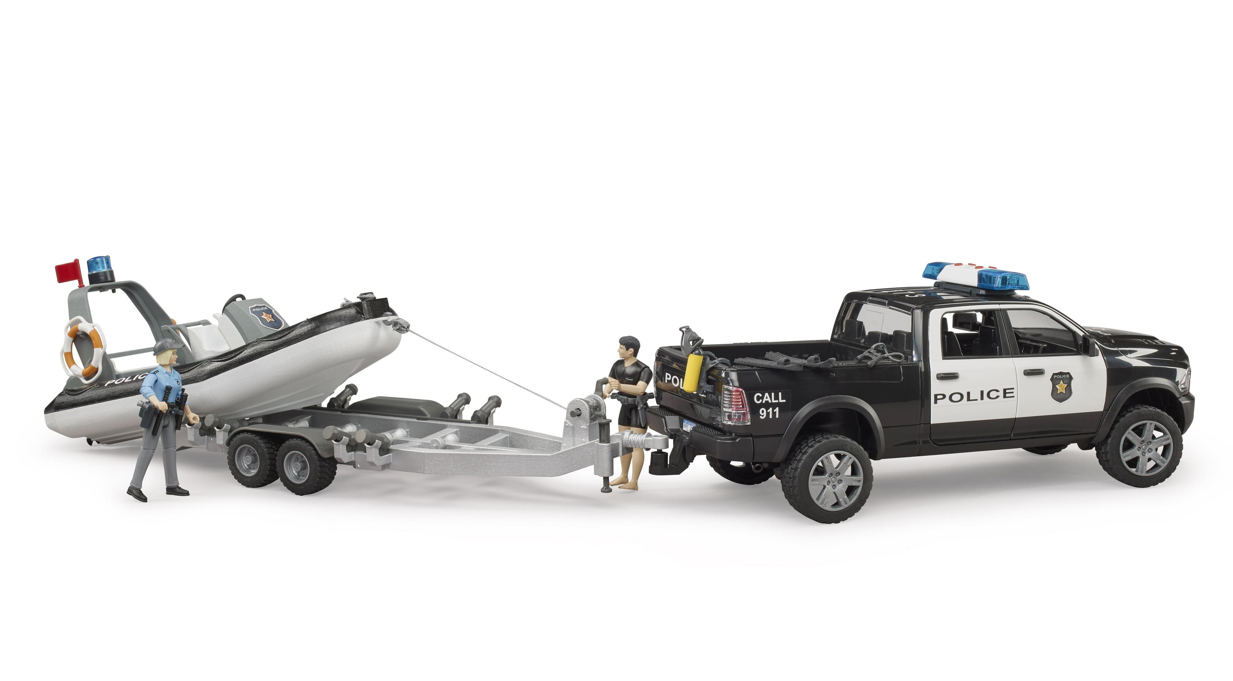 Una barca della polizia su un rimorchio è trainata da un pick-up della polizia in bianco e nero. Due figure in piedi vicino.