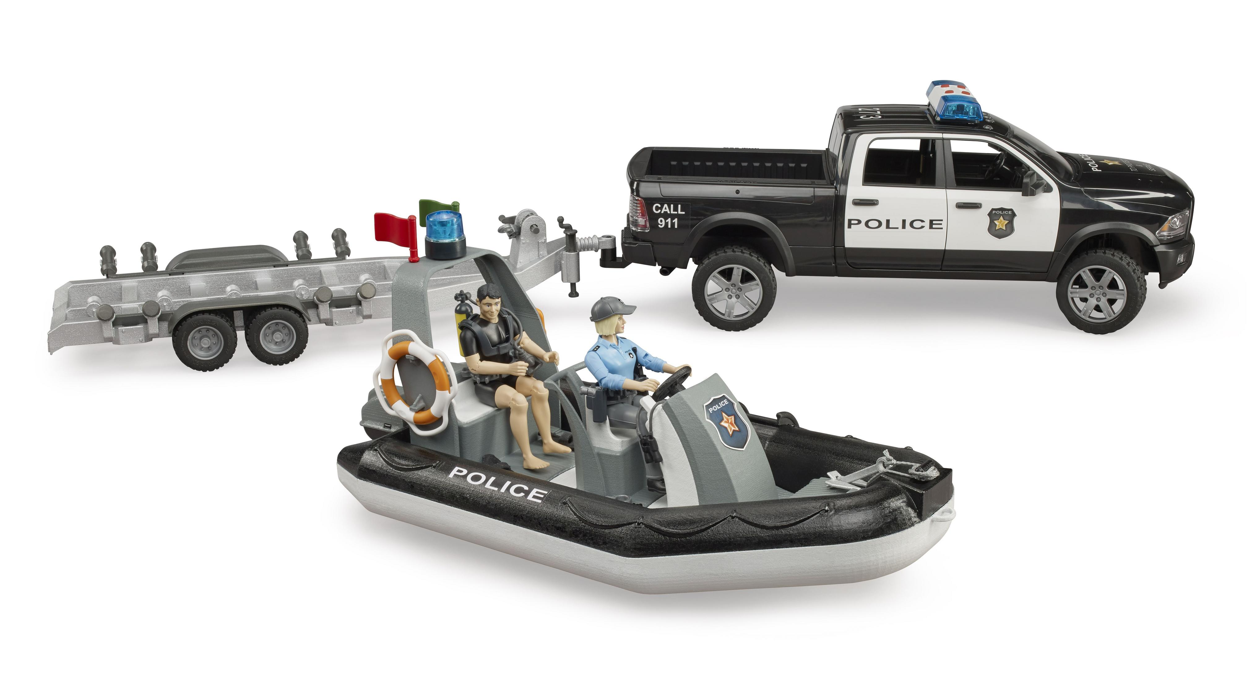 Barca della polizia giocattolo sull'acqua, con auto della polizia e rimorchio. Due personaggi giocattolo sono sulla barca.