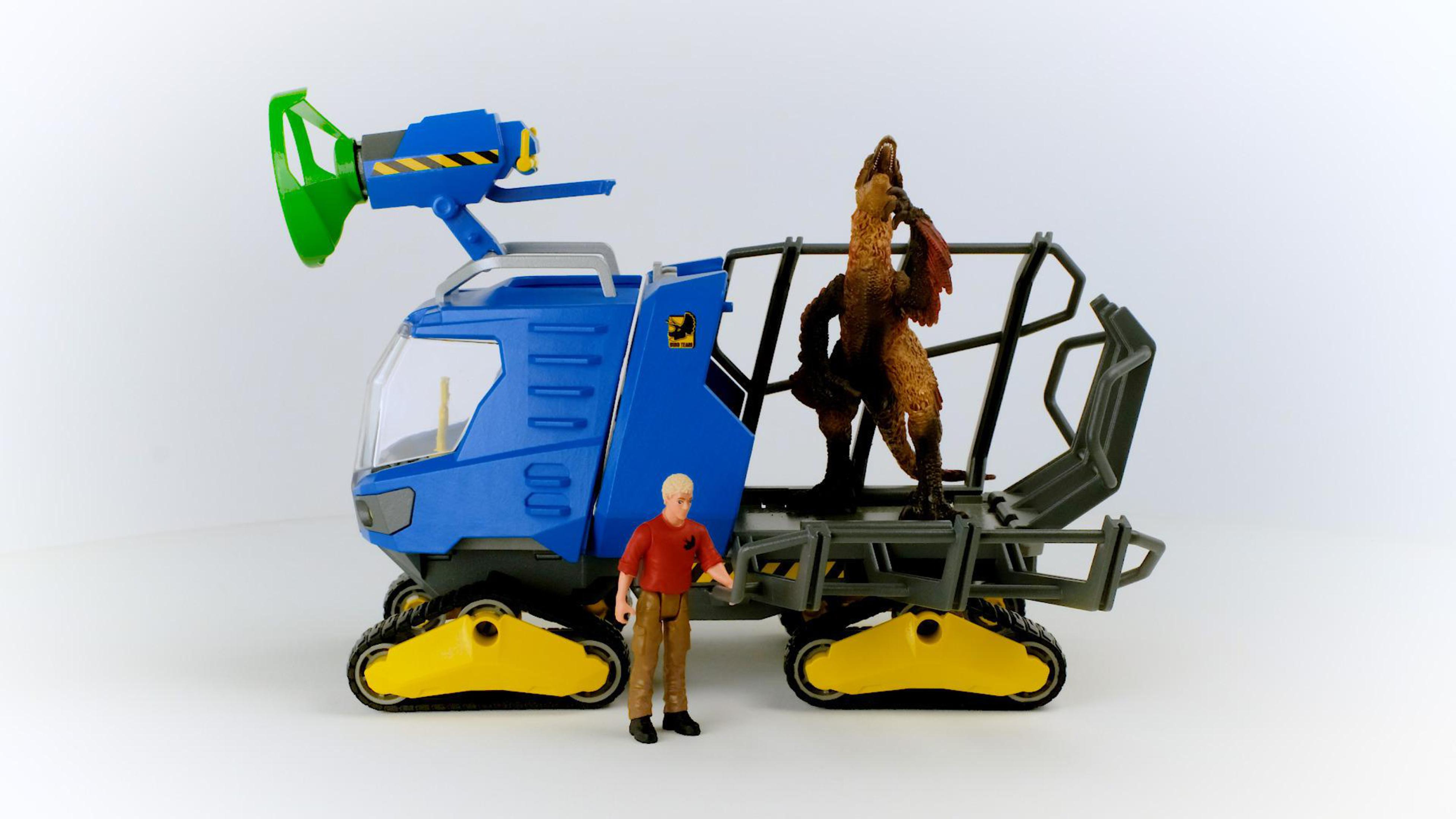 Toy vehicle with a dinosaur inside. A figure stands next to the vehicle.