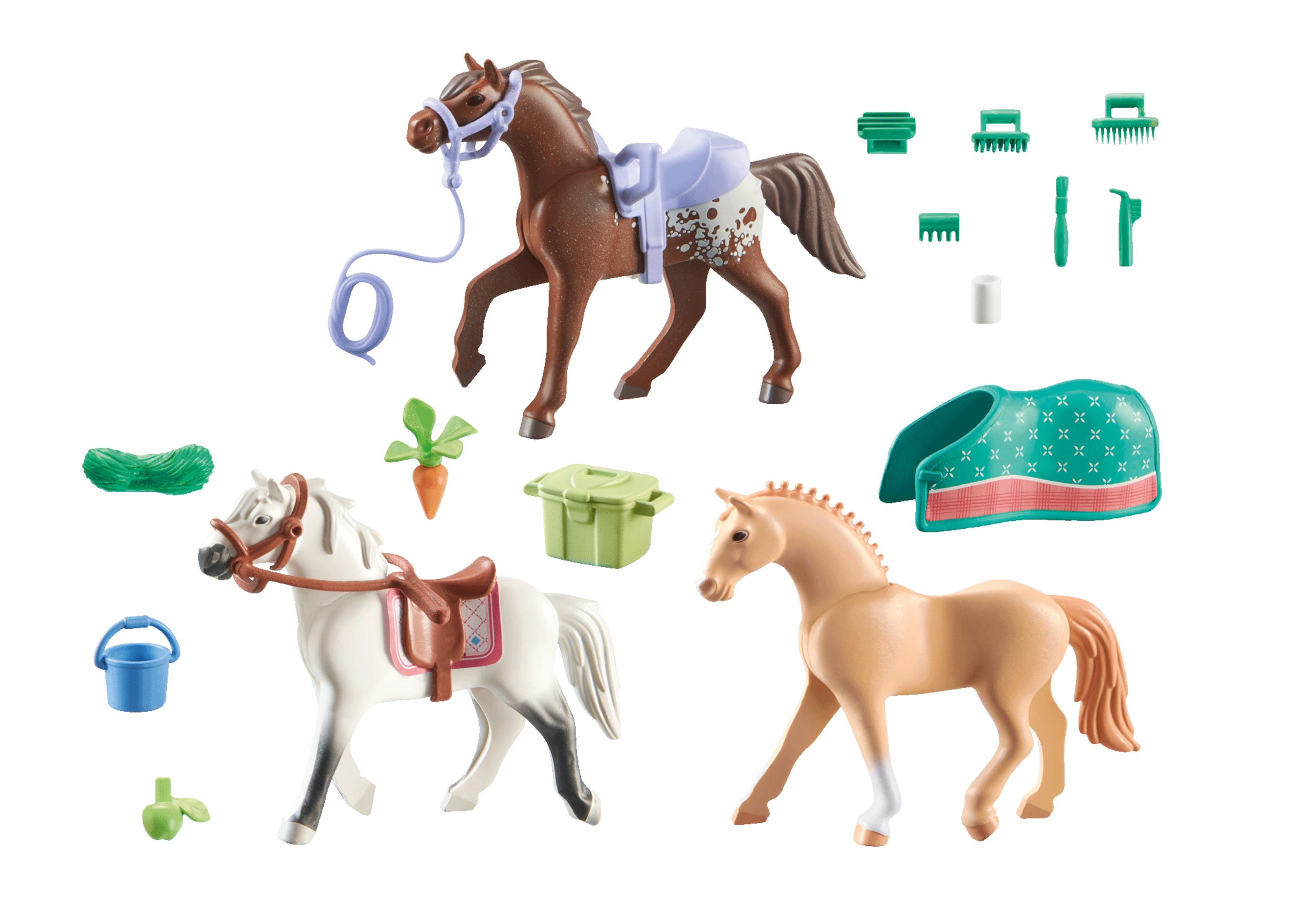 Tres caballos de juguete con accesorios como sillas de montar, cepillos y un cubo de agua sobre fondo blanco.