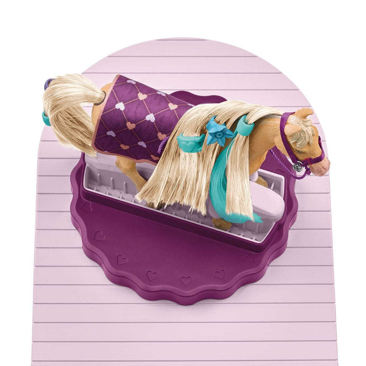 Ein Spielzeugpferd in einer violetten Putzstation mit blondem Haar und einer lila Decke auf dem Rücken.