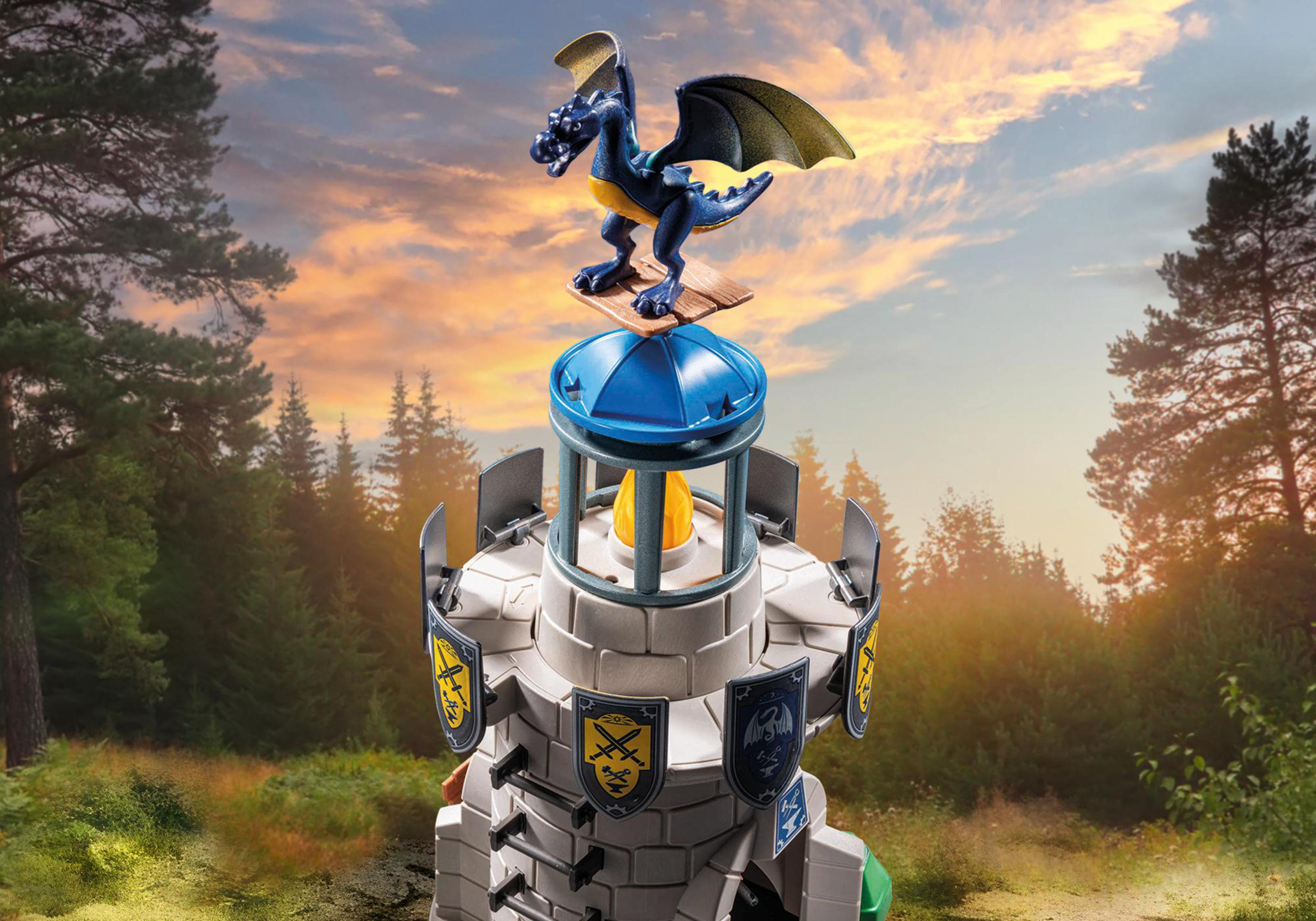 Une tour Playmobil avec un dragon au sommet, fond de forêt verte et ciel de coucher de soleil.