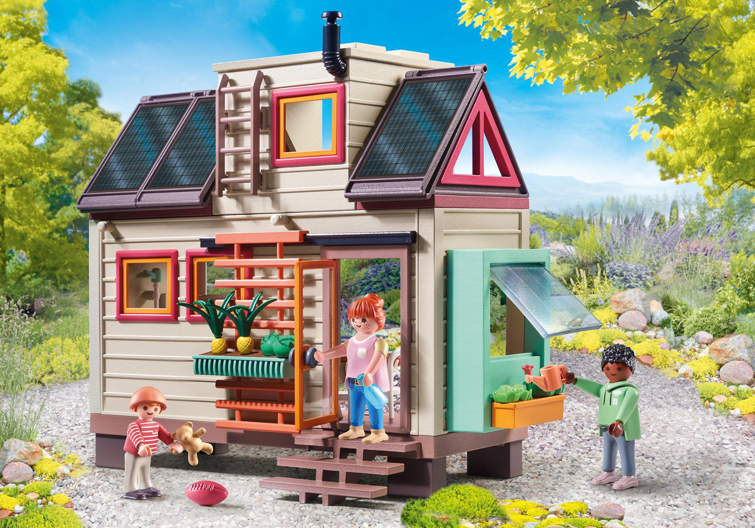Playmobil Tiny House Spielset. Zwei Personen stehen vor dem Haus. Grüner Hintergrund.