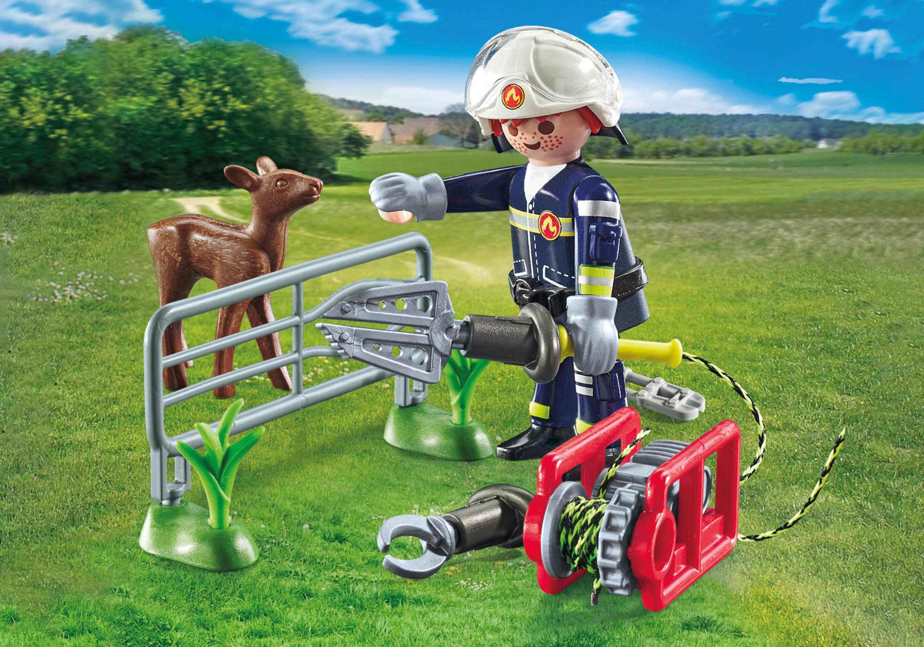 Playmobil-Feuerwehrmann mit einem Reh und einer Seilwinde. Grüner Grashintergrund. Feuerwehrmann ist in Uniform.