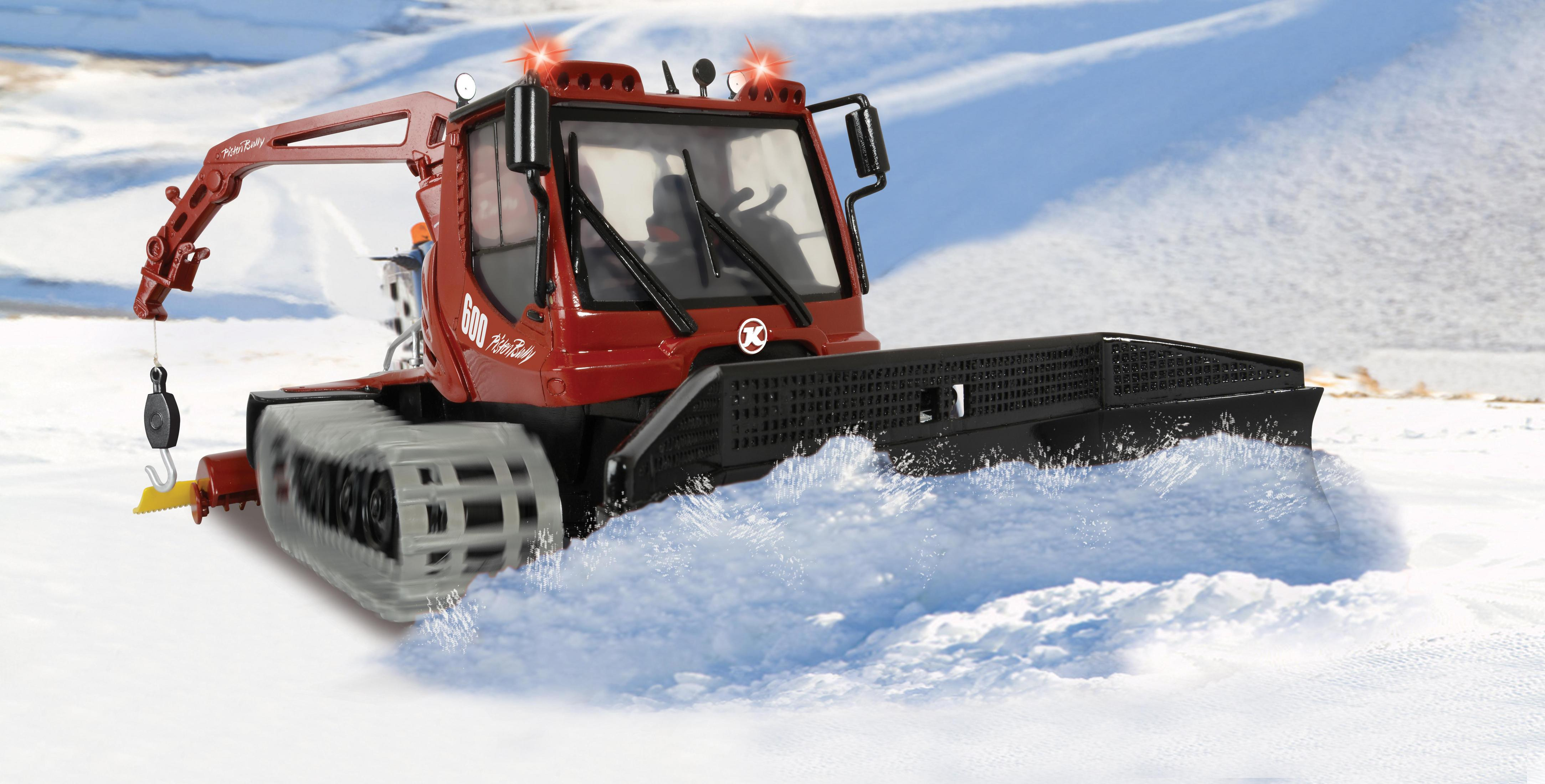 Roter Schneefräser, der Schnee pflügt, mit Winterlandschaft im Hintergrund.