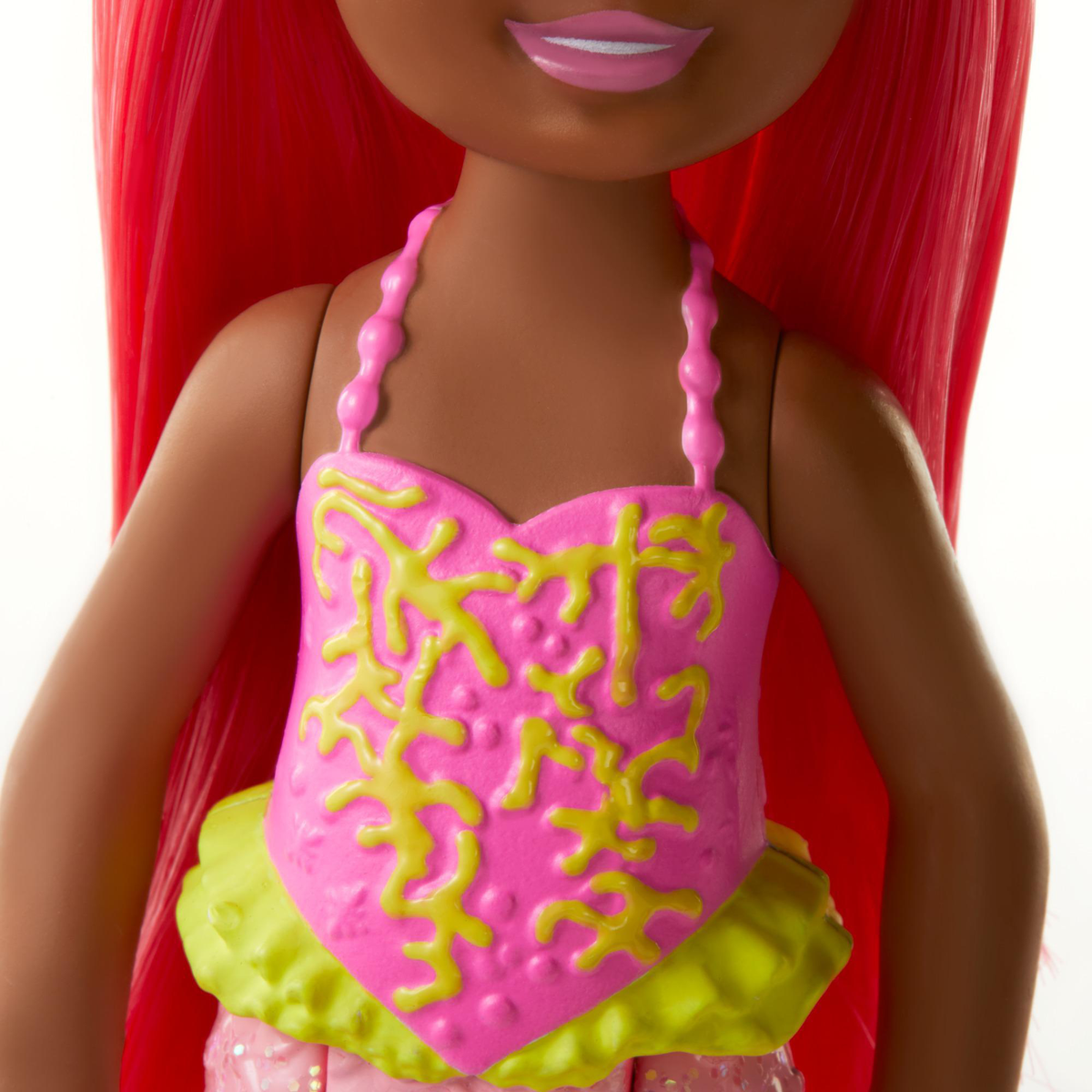 Das Gesicht einer Puppe, dunkle Haut, rosa Kleid mit gelben Akzenten und rotes Haar.