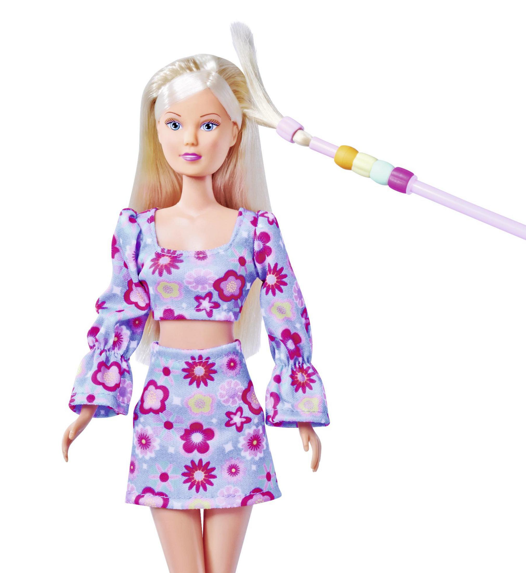 Blonde Puppe in Blumen-Outfit, Haare werden mit pinkem Werkzeug gestylt, weißer Hintergrund.