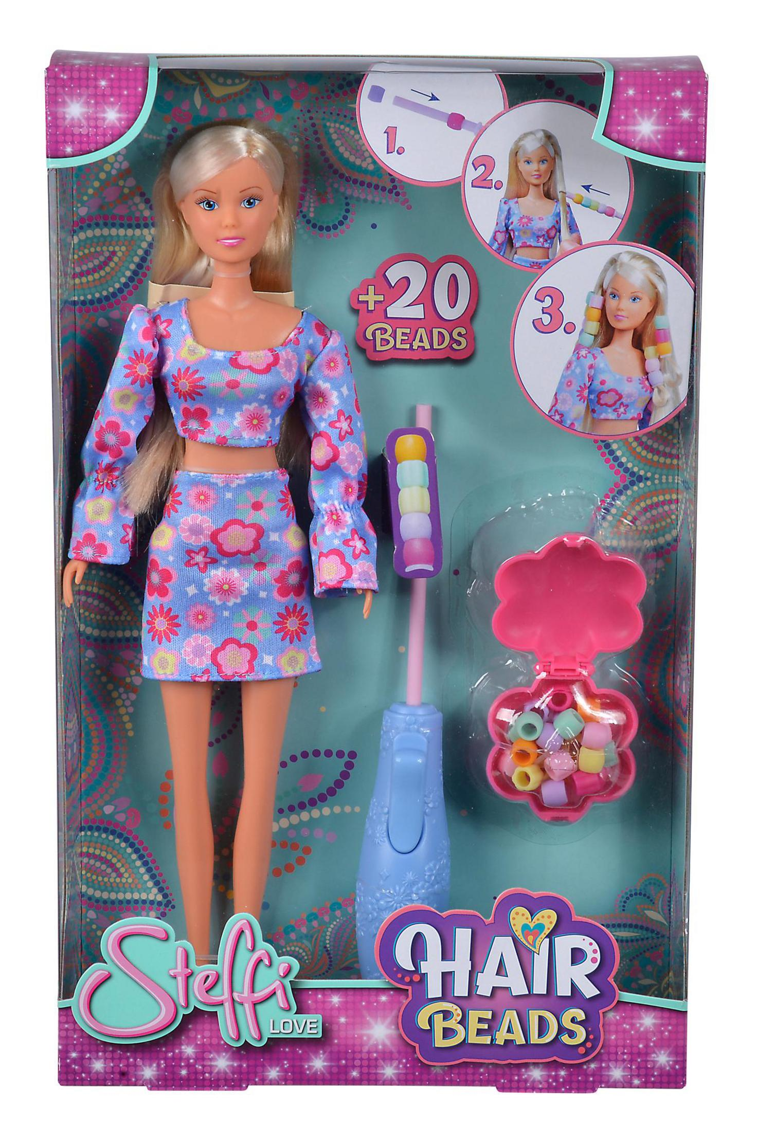 Eine Puppe in einem floralen Outfit mit Haarperlen und einem Perlenwerkzeug in einer Box.