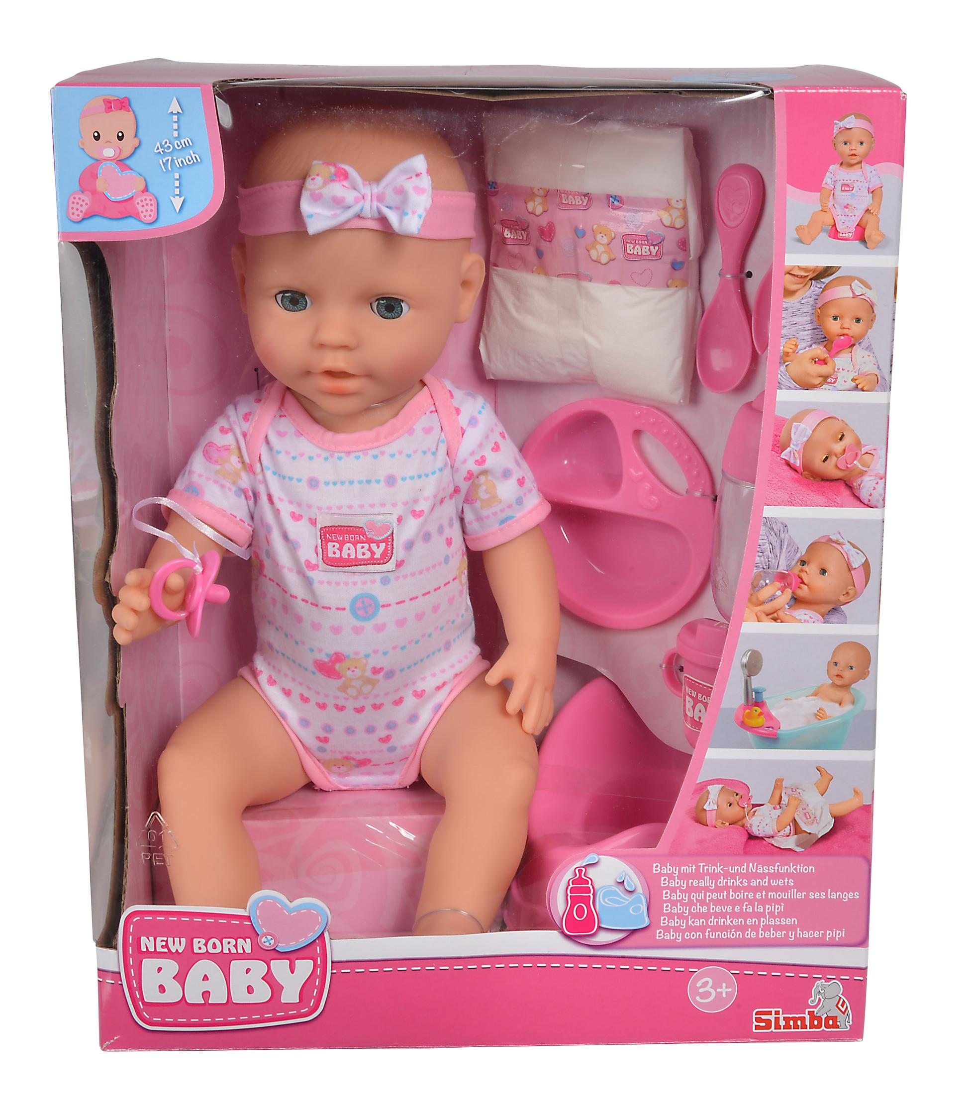 Spielzeug-Babypuppe in einer Box. Die Puppe trägt rosa Kleidung, Zubehör sichtbar.