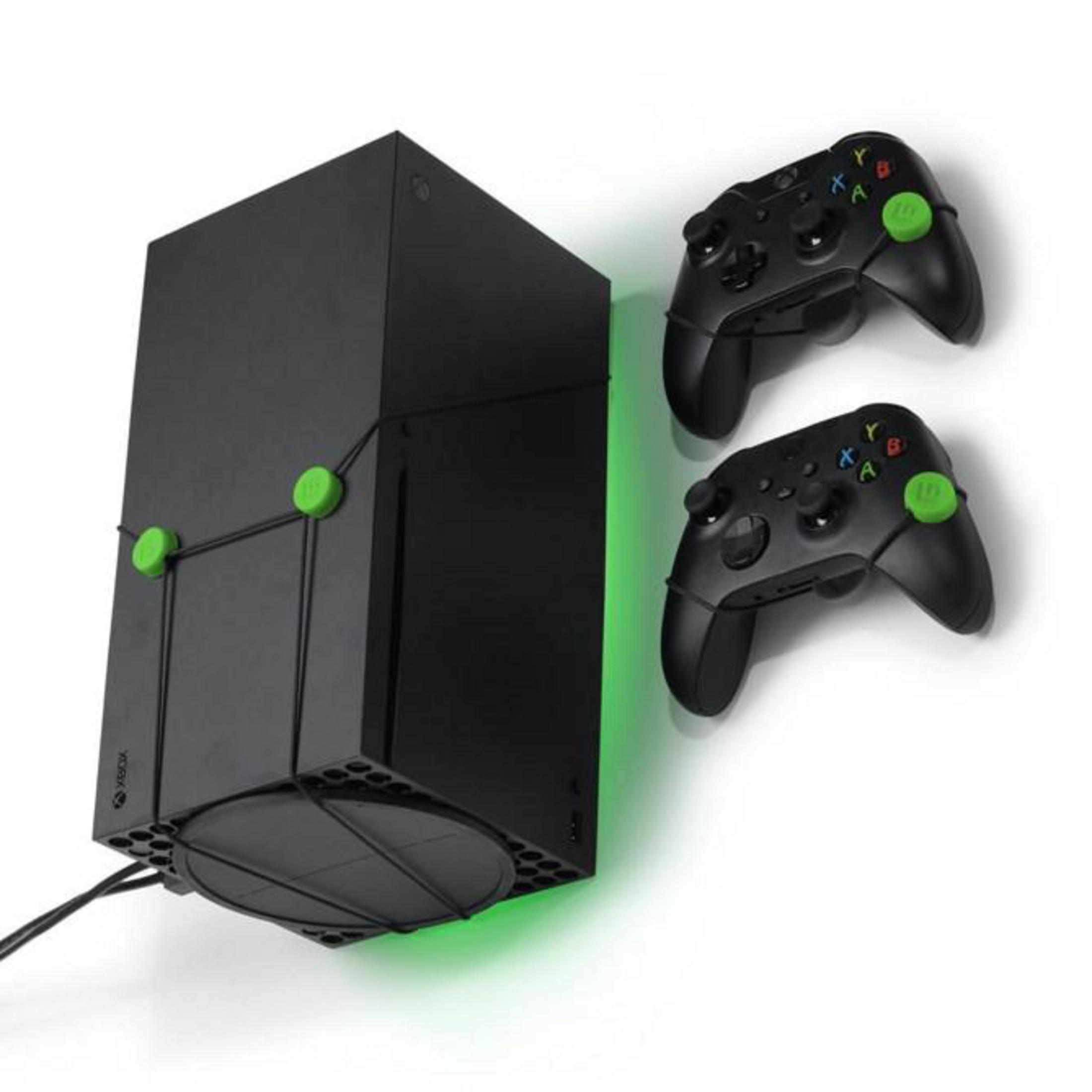 Schwarze Xbox Series X Konsole an der Wand, mit zwei schwarzen Controllern.