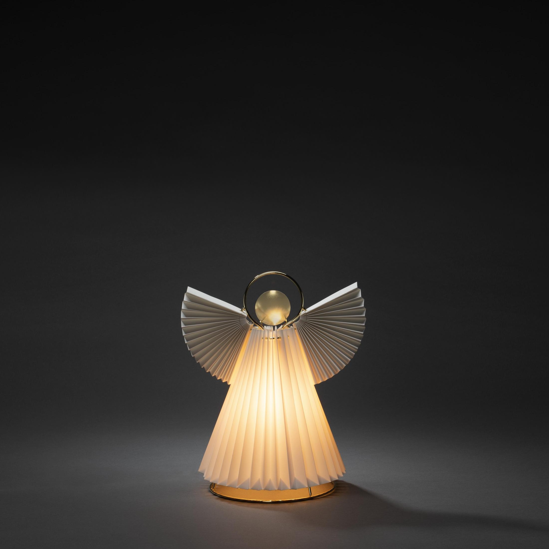 Eine engelartige Lampe mit gefalteten Flügeln. Sie ist weiß und gold, mit dunklem Hintergrund.
