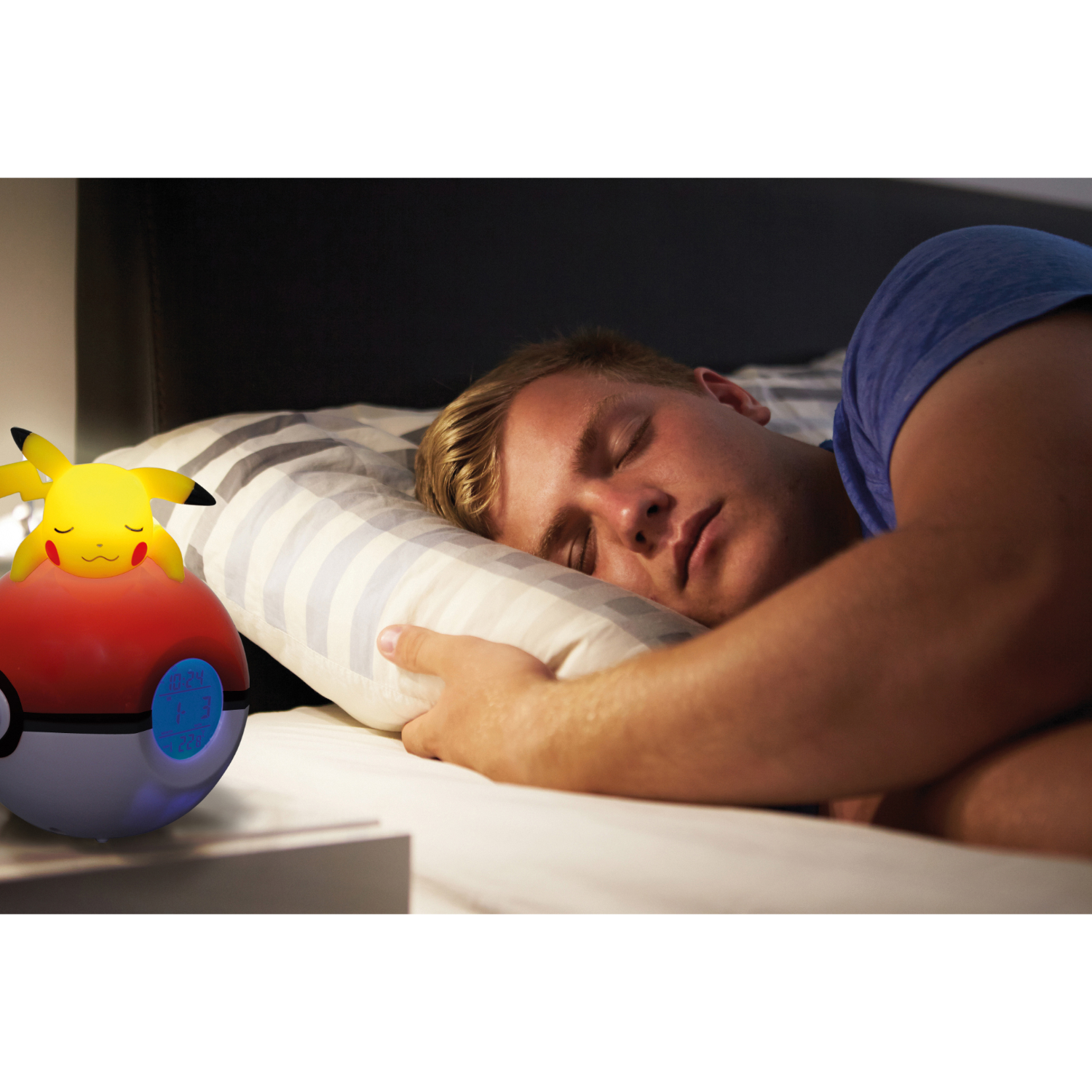 Mężczyzna śpiący w łóżku z budzikiem Pikachu.