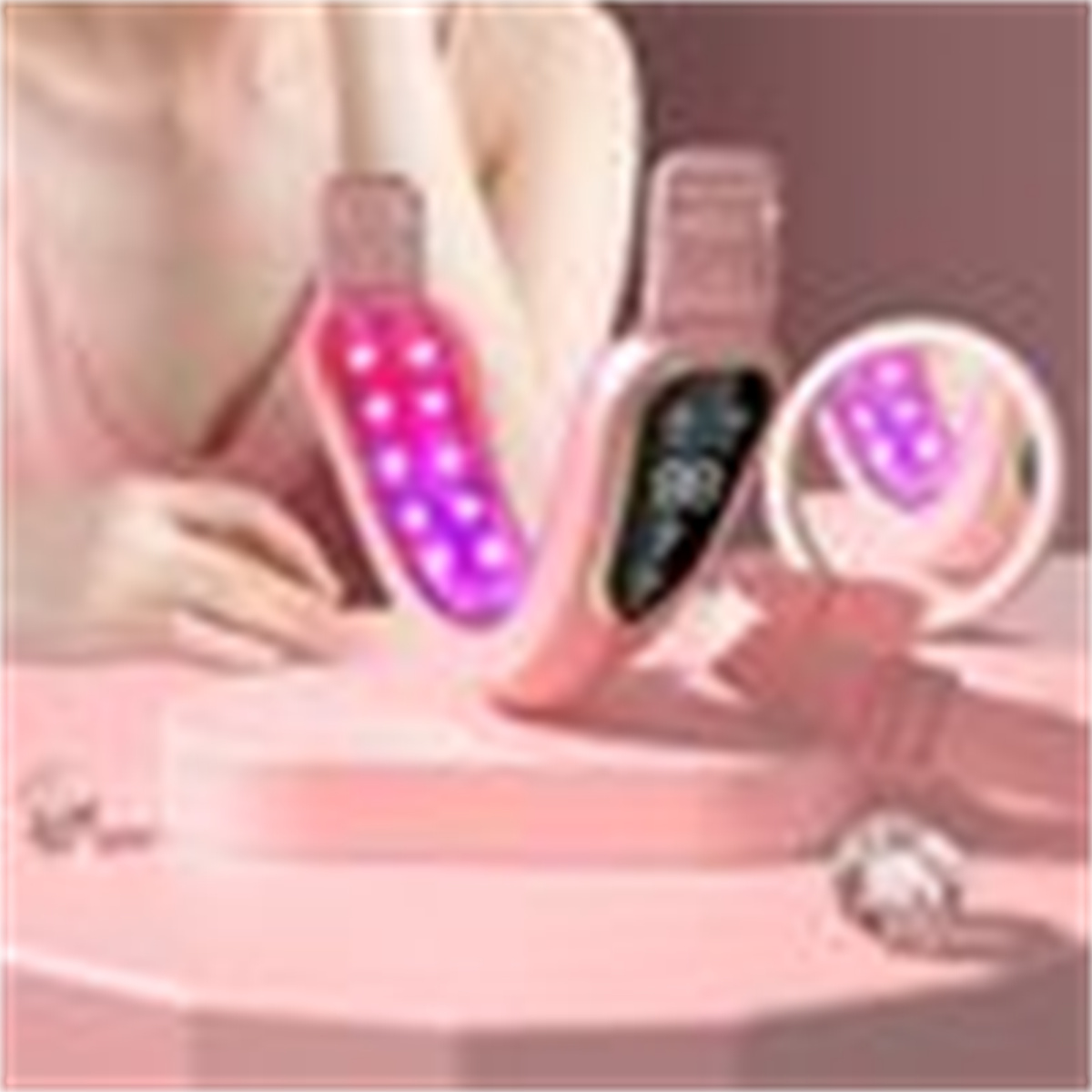 Zwei rosa Beauty-Tools mit Lichtern auf einer rosa Oberfläche. Ein Spiegel ist im Hintergrund.