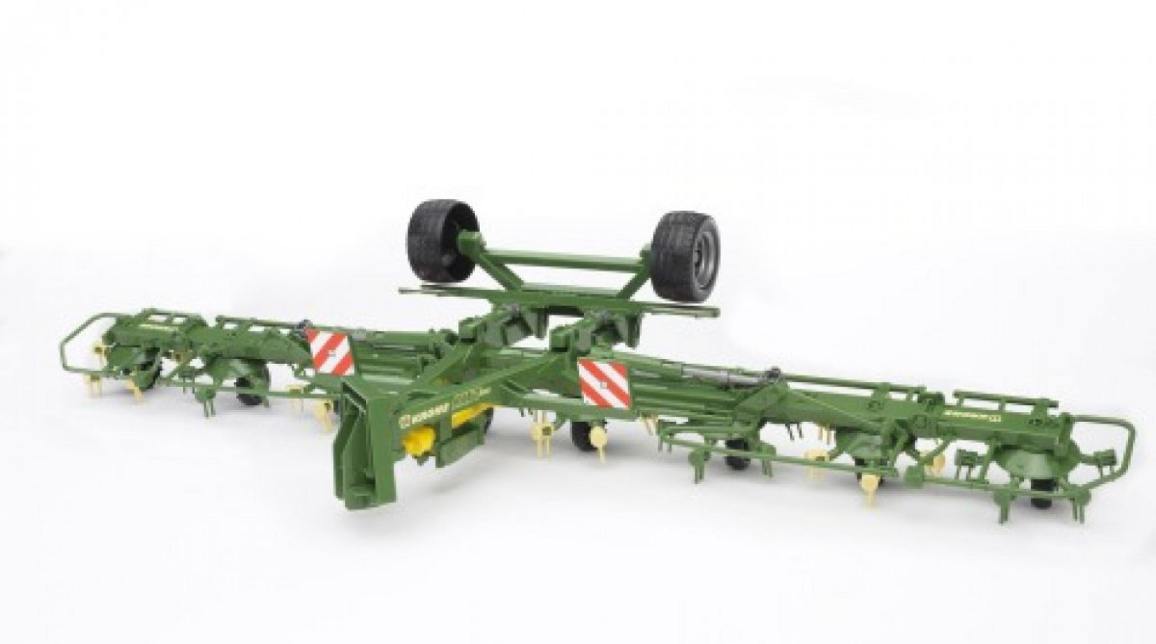 Zielona zabawka rolnicza. Jest to długie, szerokie narzędzie z kołami. Białe tło.