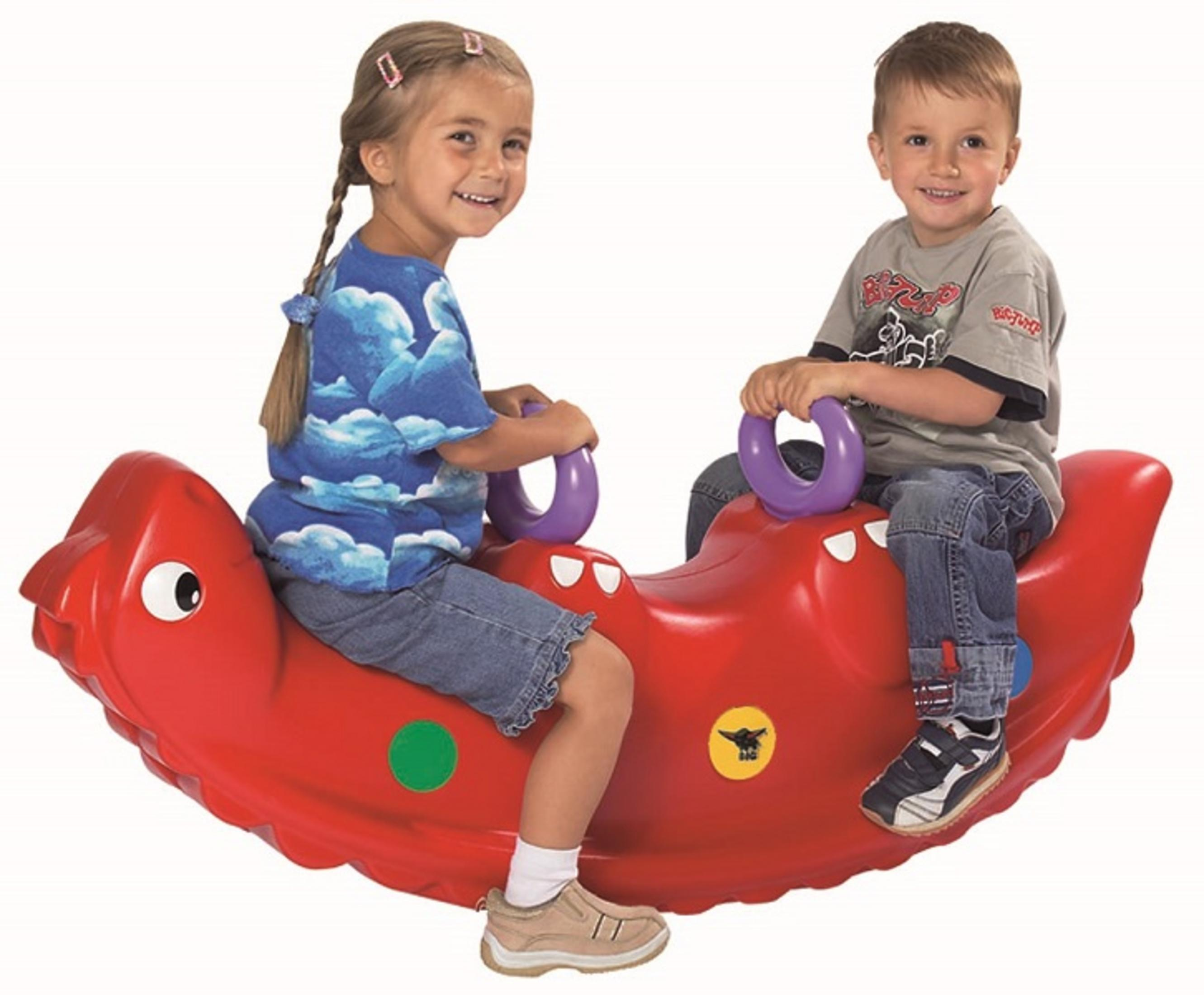 Dos niños en un balancín rojo con forma de dragón, sonriendo, sobre un fondo blanco.