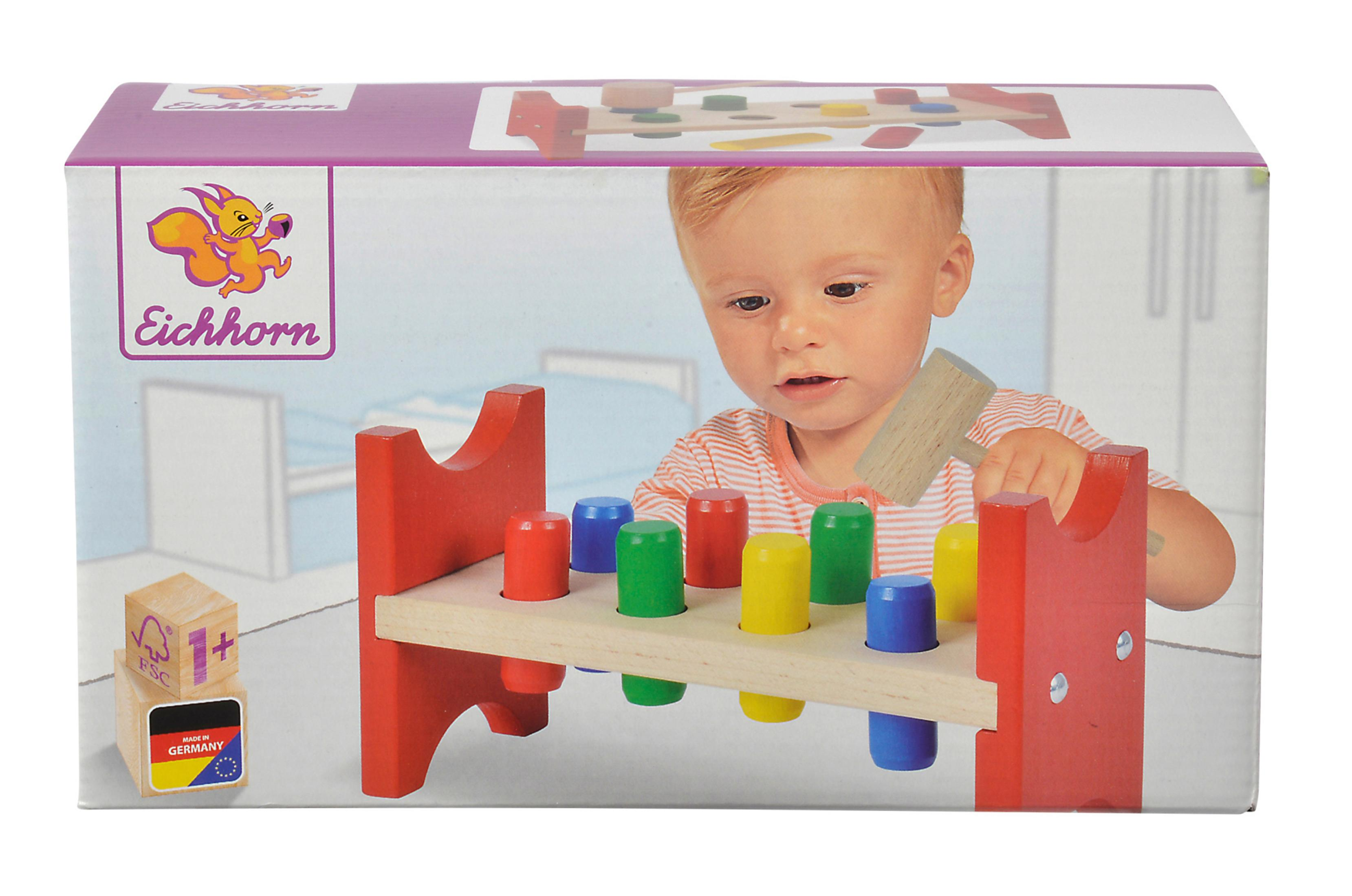 Kiste des Eichhorn Spielzeugs mit einem Baby, das mit einem Hammer-Spielzeug spielt. Die Kiste steht auf einer weißen Oberfläche.