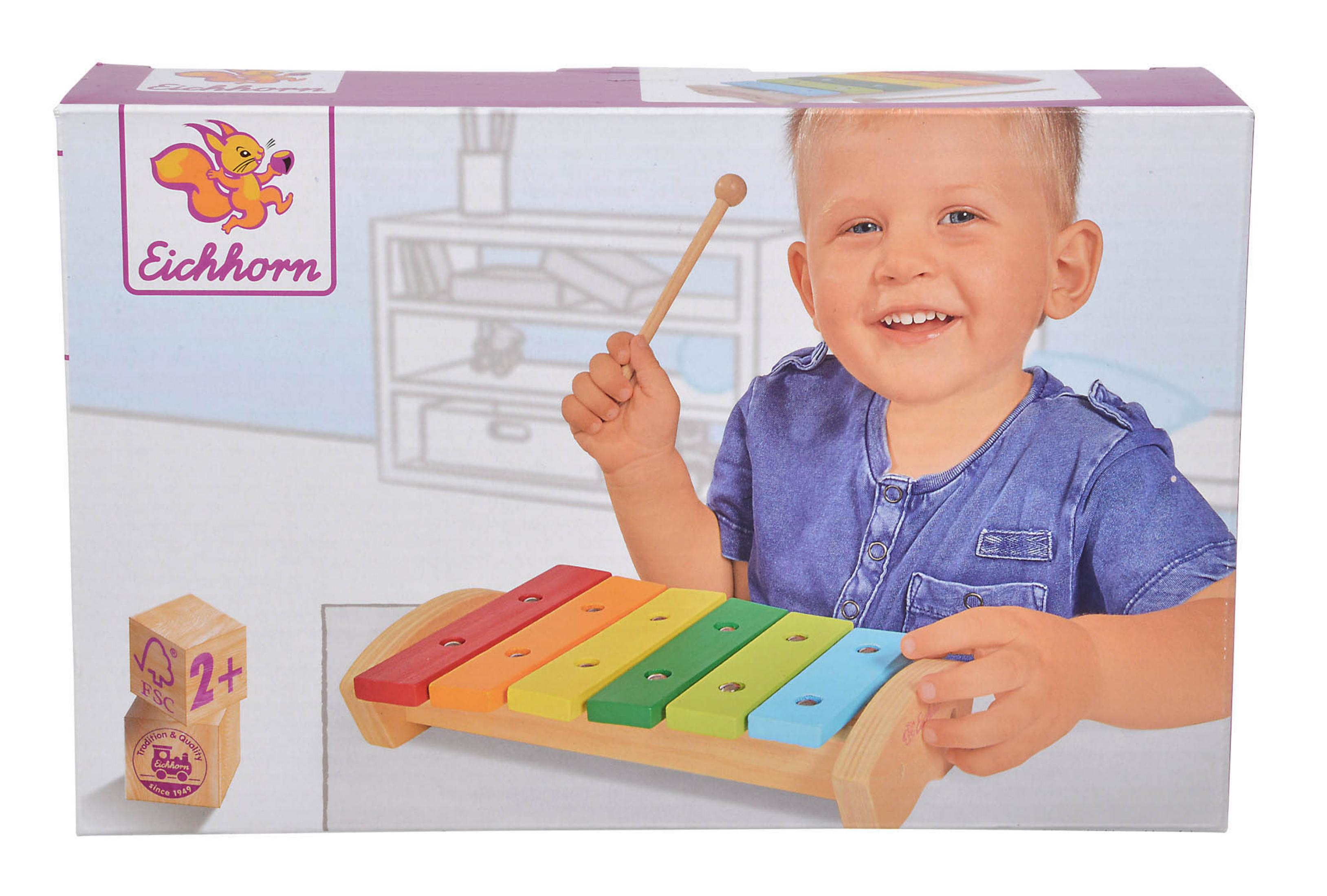 Spielzeug-Xylophon in einer Box mit lächelndem Kind und Blöcken mit FSC-Logo.