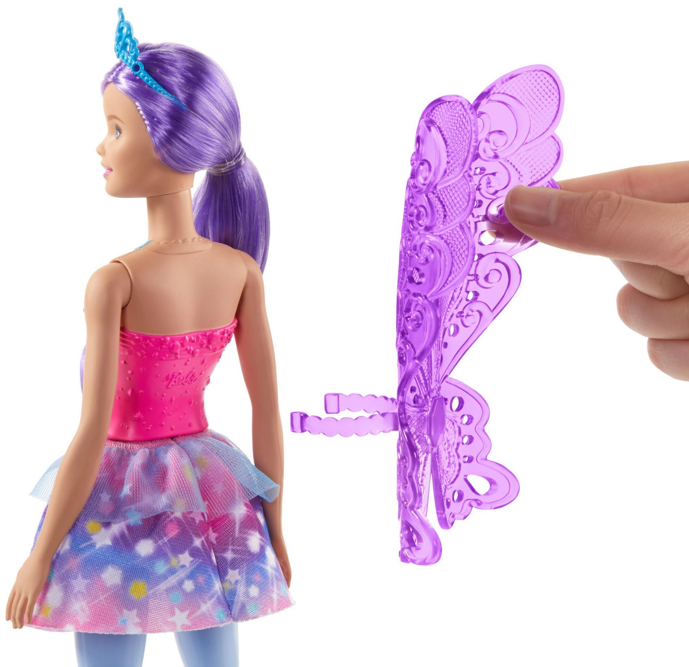 Eine Barbie-Puppe mit pinkem Oberteil und lila Haaren mit Flügelzubehör.