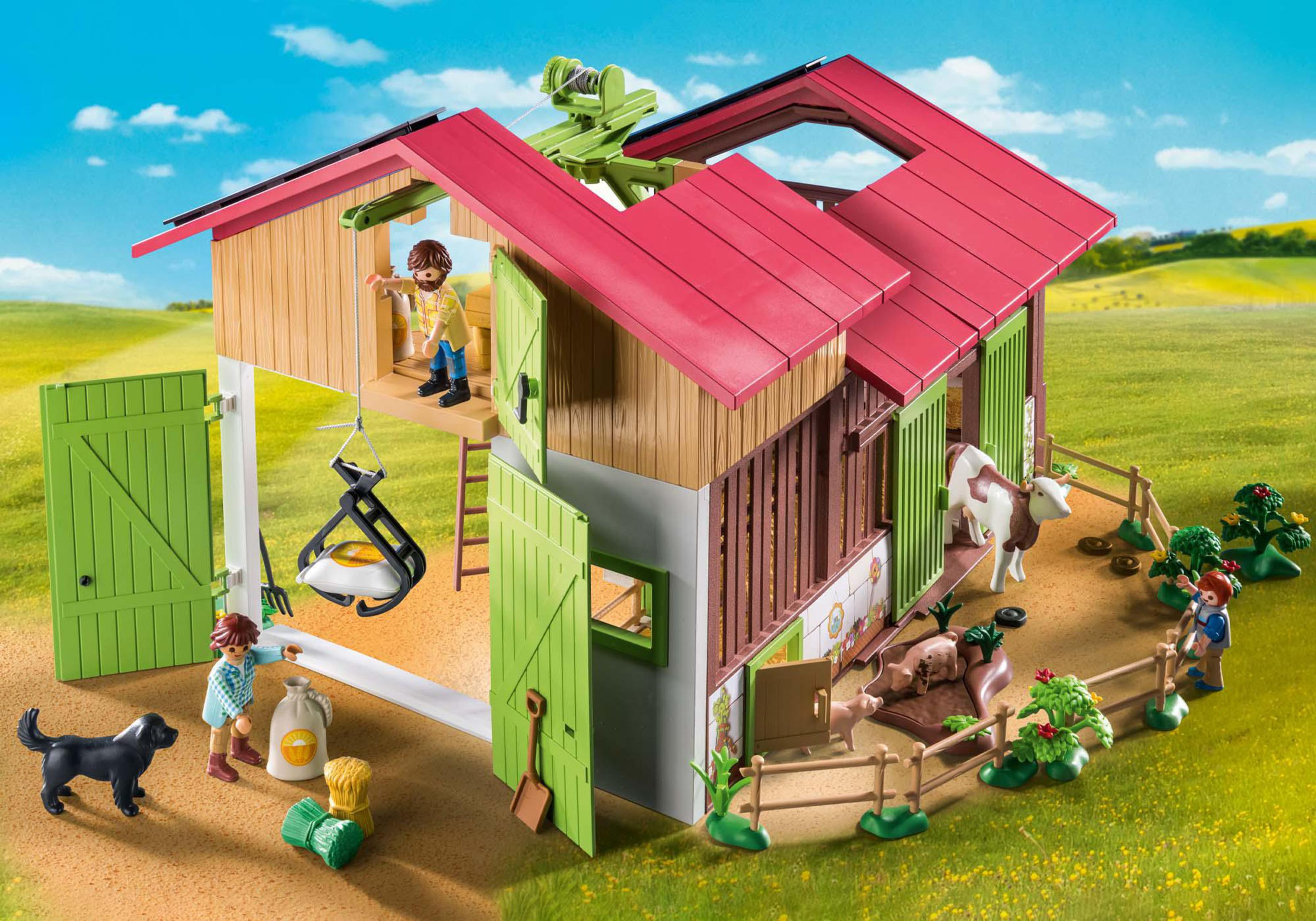 Eine Spielzeug-Bauernhofszene mit Scheune, Figuren und Tieren. Kühe, Schweine und Menschen sind enthalten.