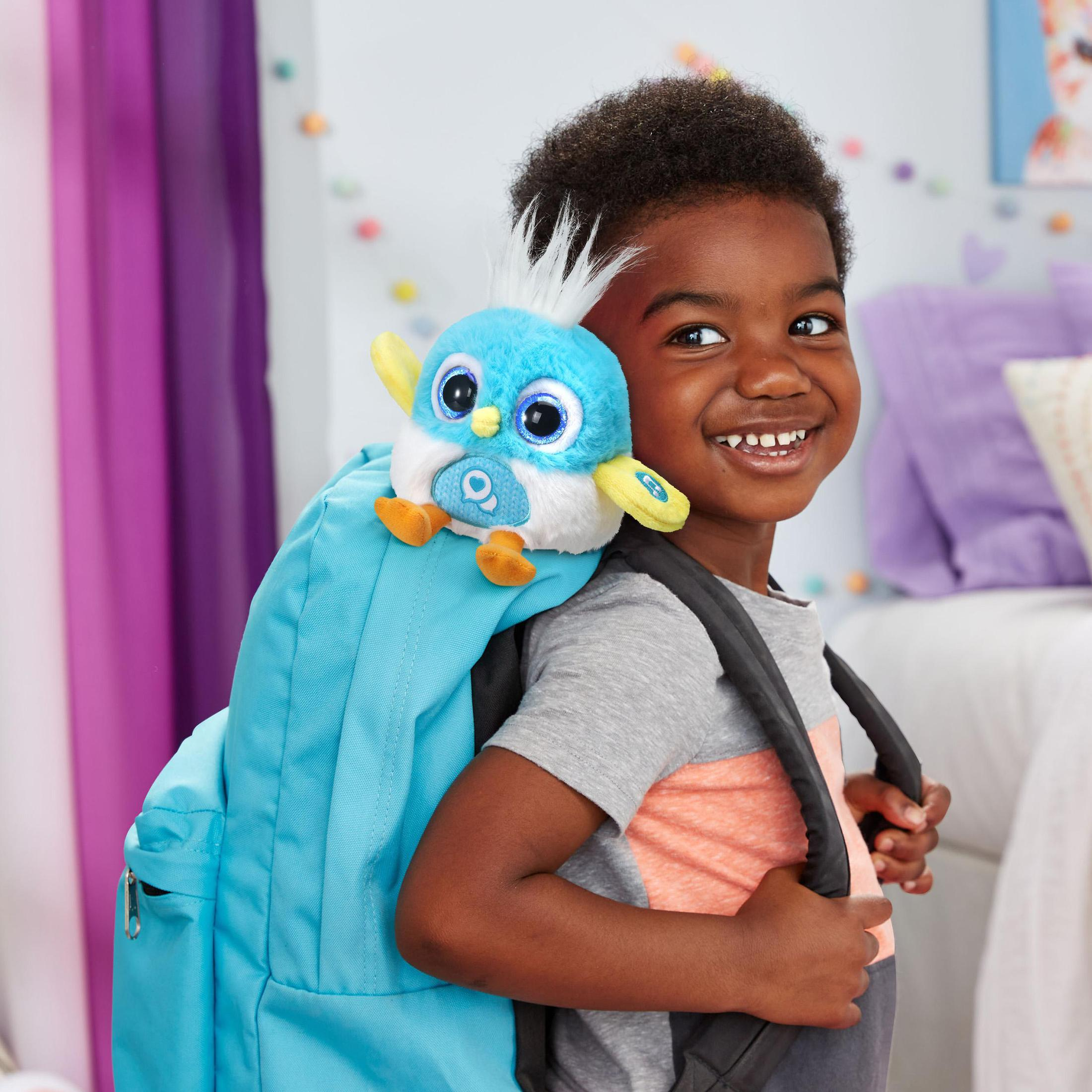 Ein Junge mit einem blauen Rucksack hat einen Spielzeugvogel darauf. Der Vogel ist blau und weiß.