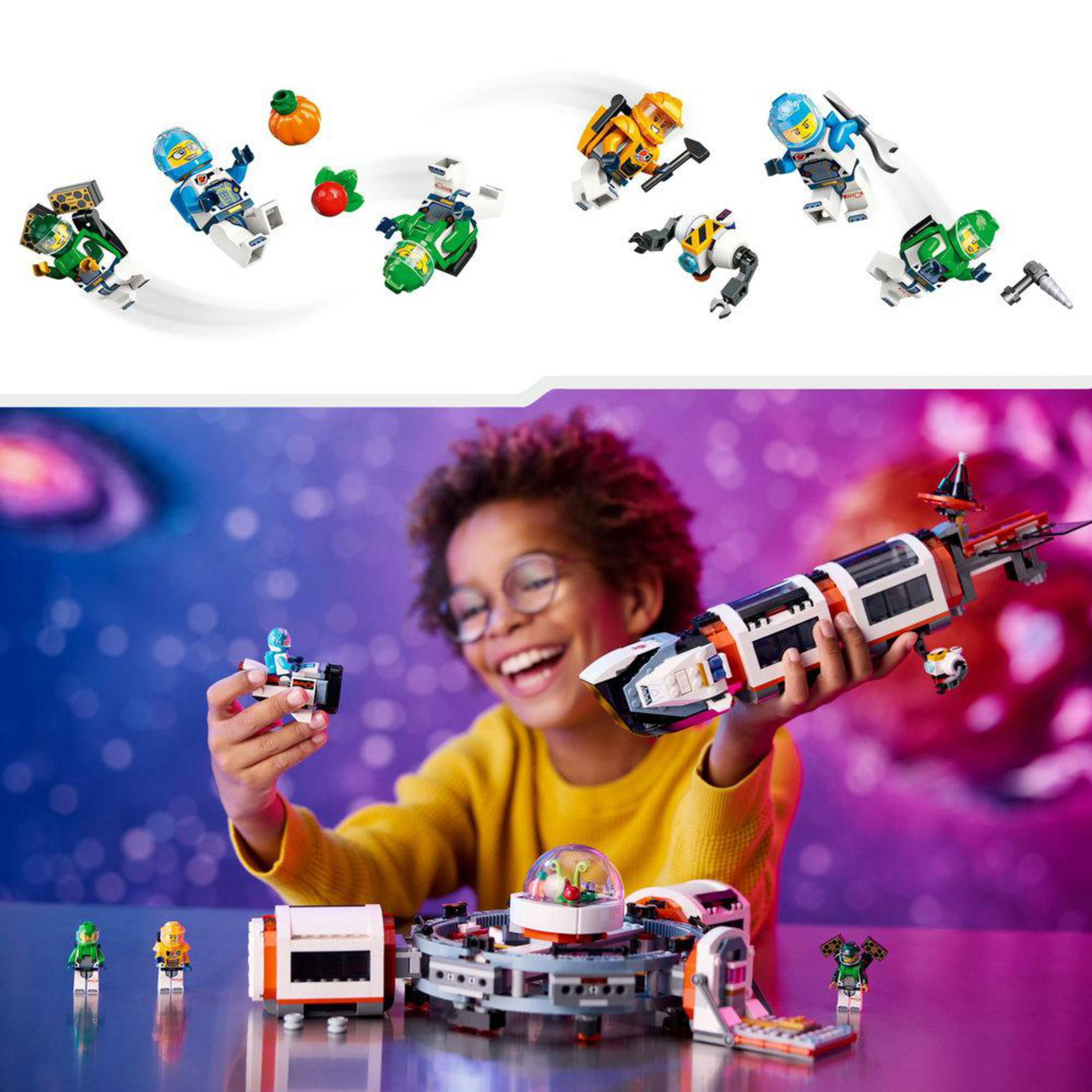 Un niño sonriendo, sosteniendo una nave espacial de juguete, con astronautas y vehículos Lego.