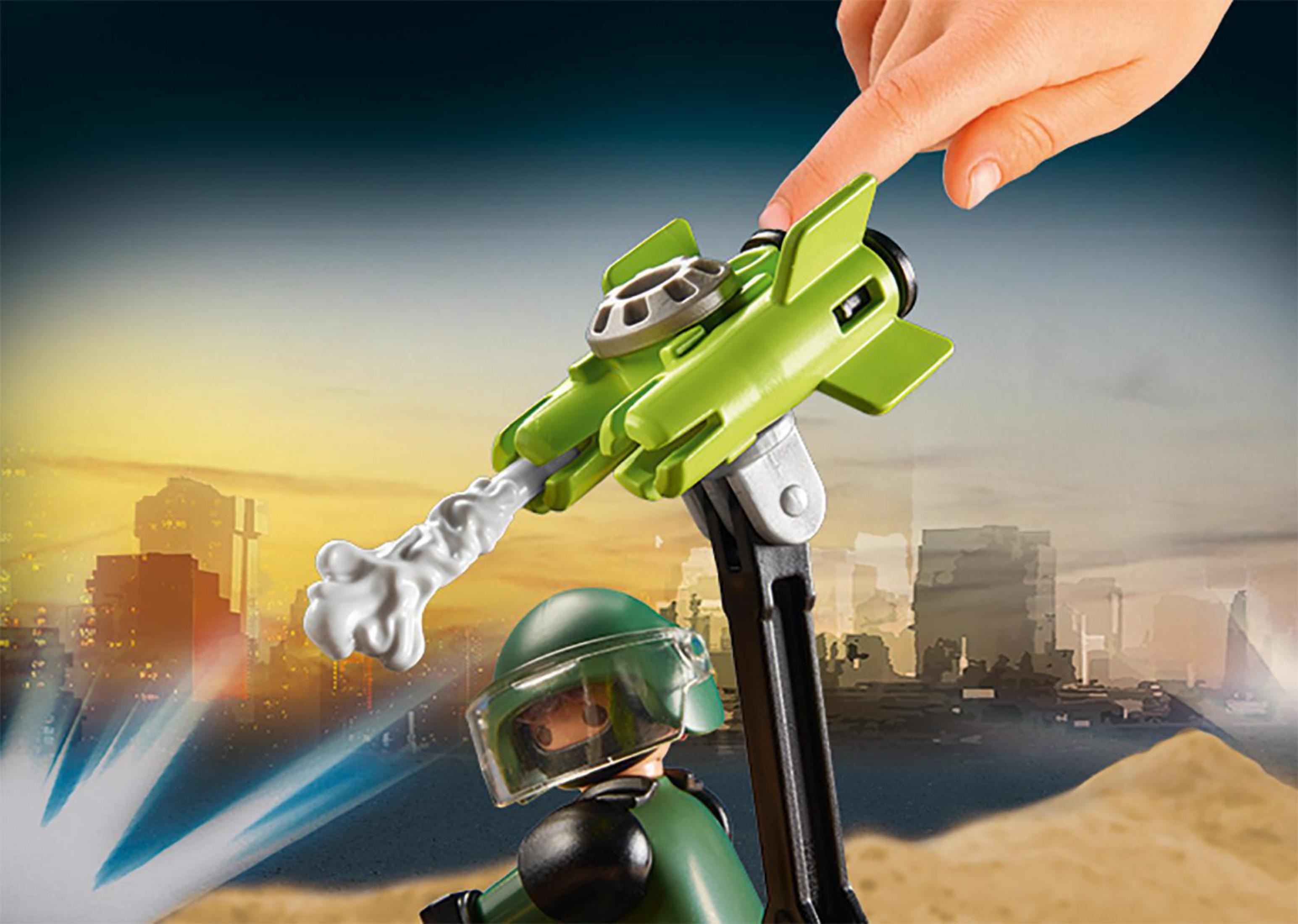 Zabawkowy żołnierz strzela zielonym pociskiem w stronę krajobrazu miejskiego.