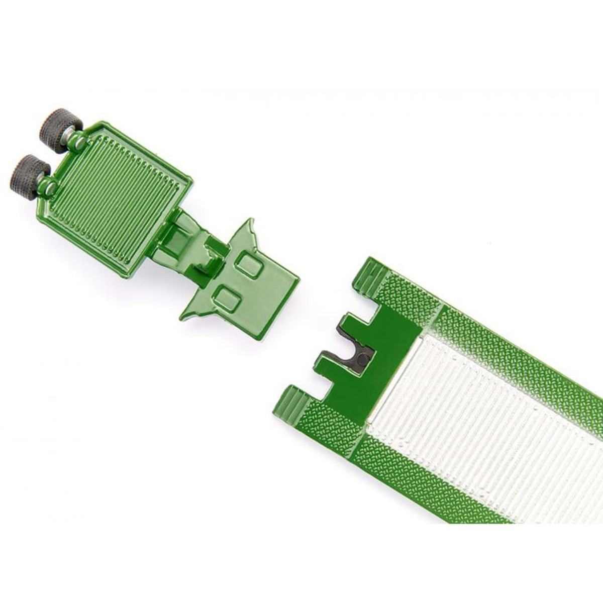 Primer plano de piezas de remolque de juguete verdes. Las piezas están separadas sobre un fondo blanco.