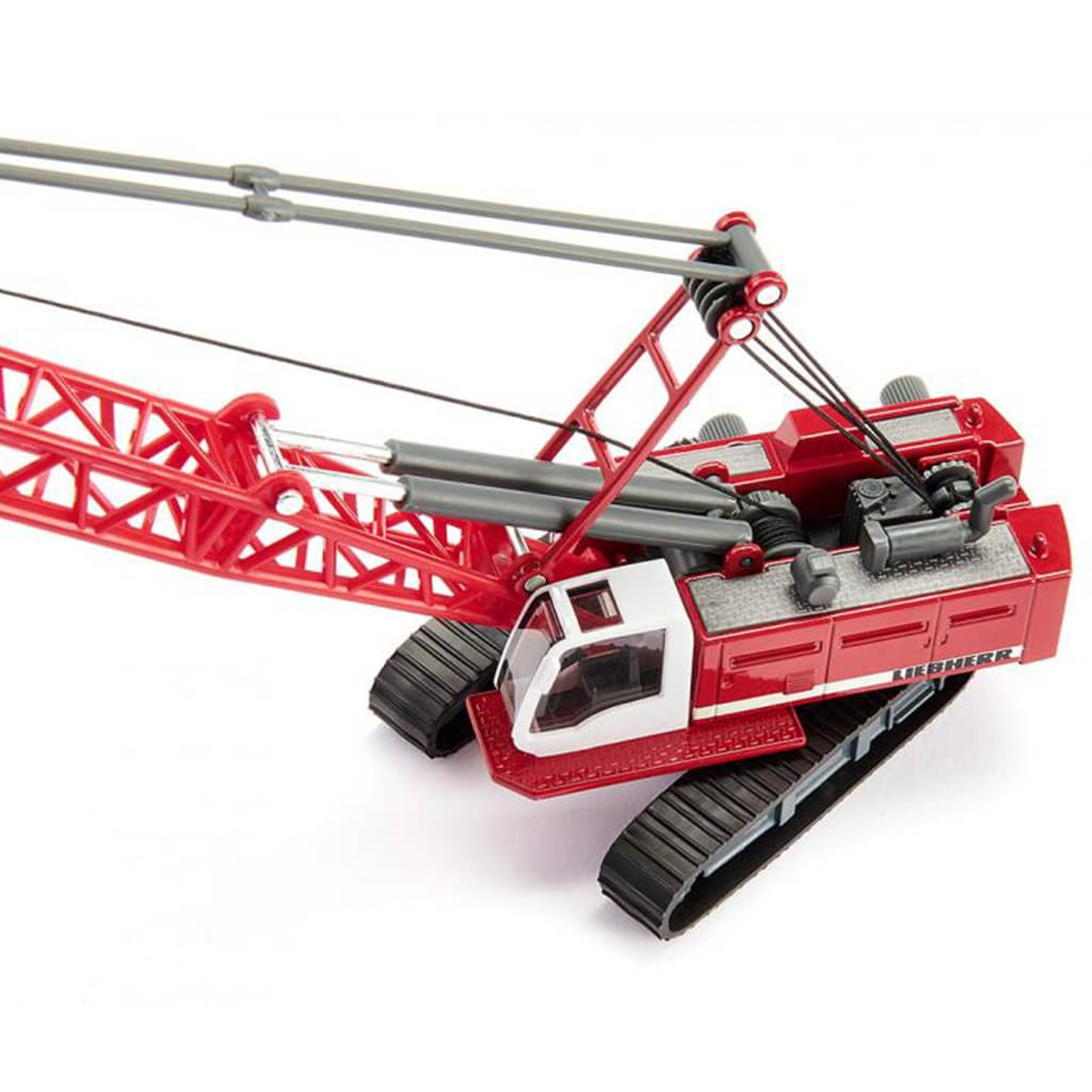 Grúa Liebherr de juguete roja y blanca. La grúa está sobre orugas y tiene una pluma larga.