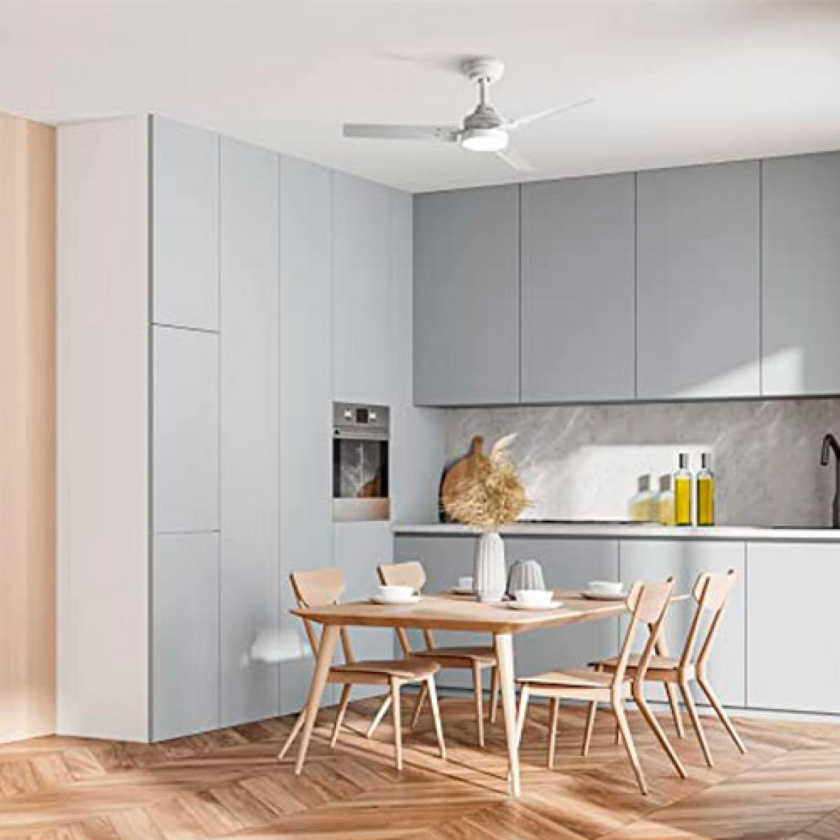 Nowoczesna kuchnia z jasnoniebieskimi szafkami, drewnianym stołem i krzesłami oraz wentylatorem sufitowym.