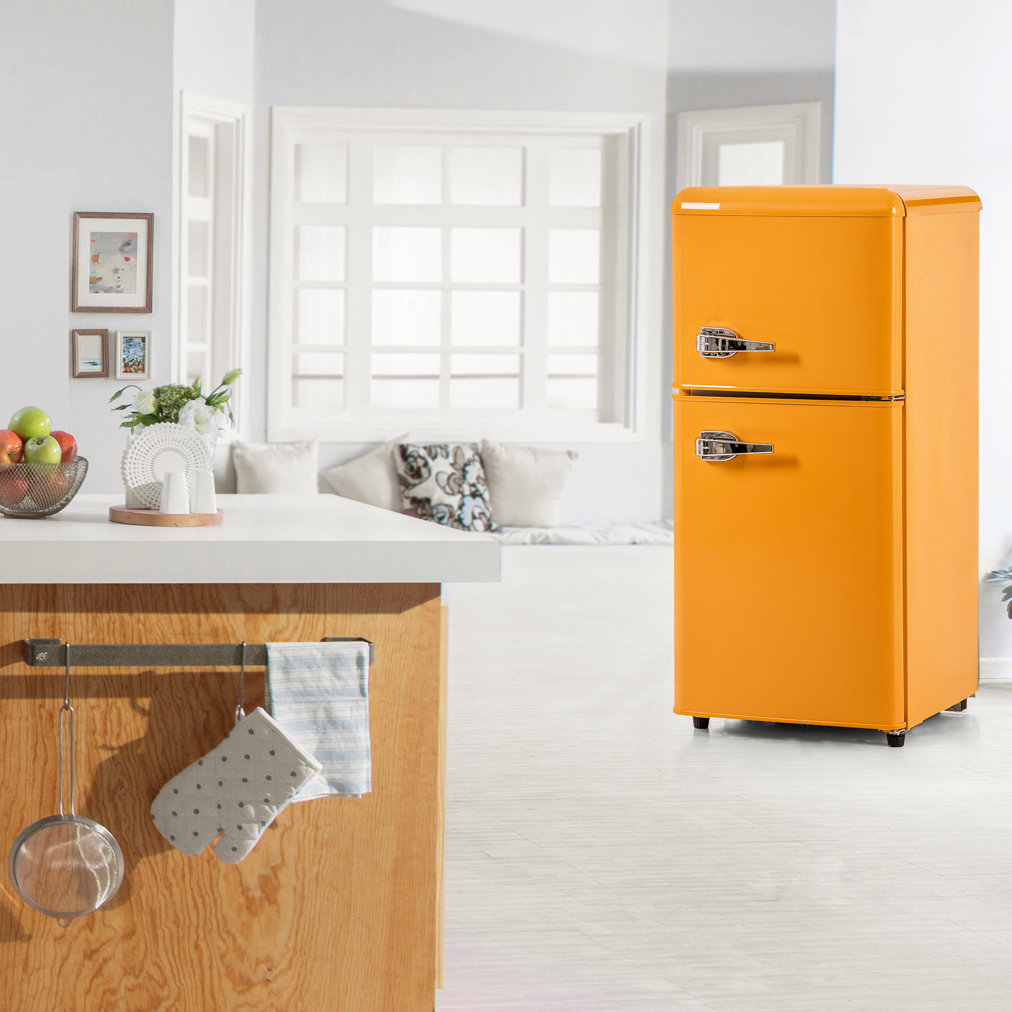 Eine Küche mit einem orangefarbenen Retro-Kühlschrank, einer weißen Arbeitsplatte und einem Fenster im Hintergrund.