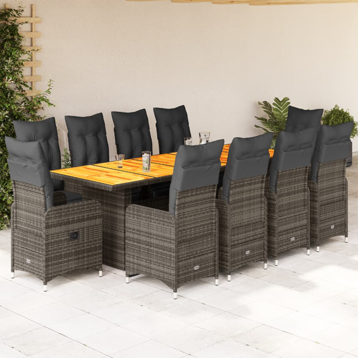 Set da pranzo all'aperto: un tavolo e 8 sedie. Il tavolo ha un piano in legno. Le sedie sono in vimini con cuscini grigi.