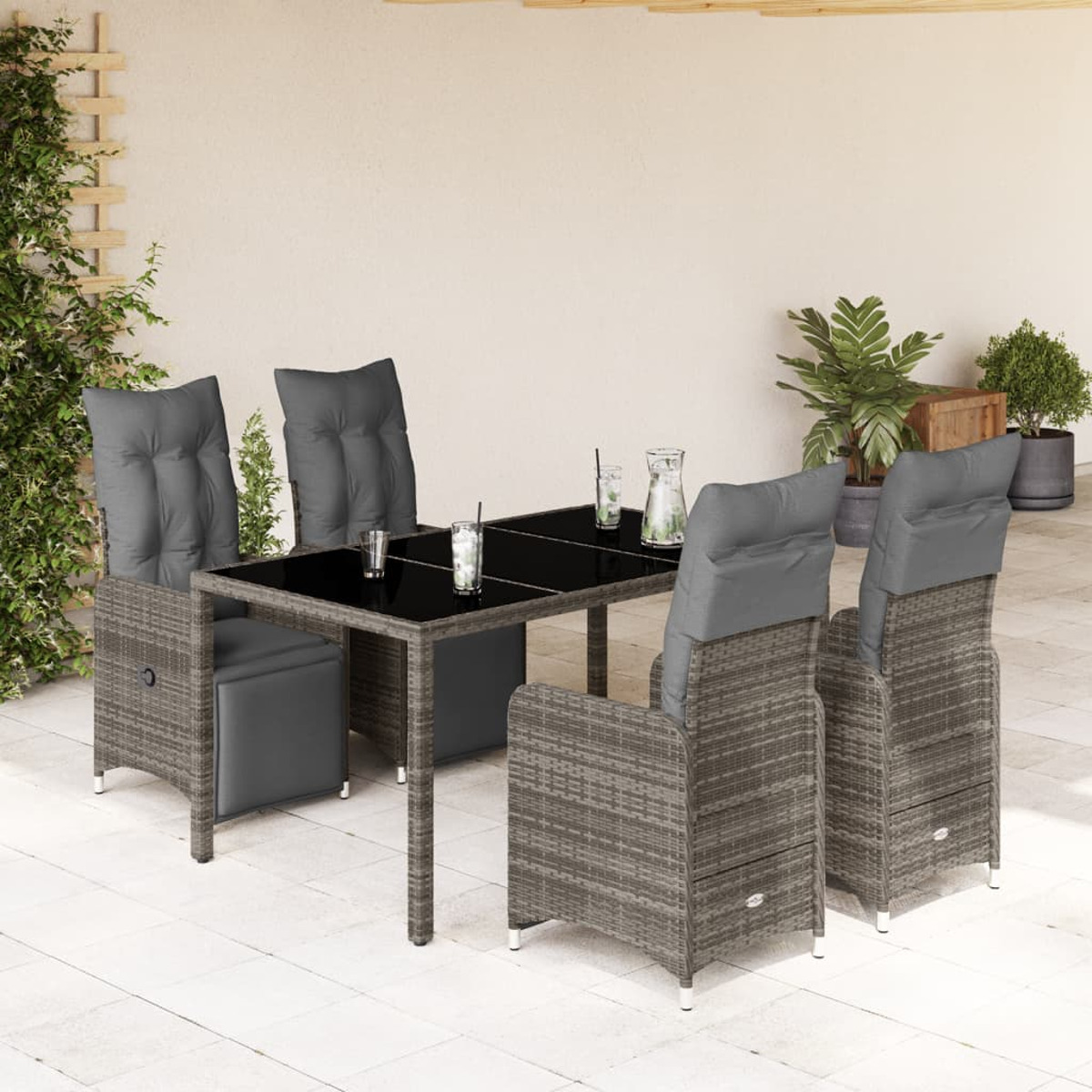 Essgruppe im Freien mit Tisch, Stühlen und Kissen auf einer sonnigen Terrasse.