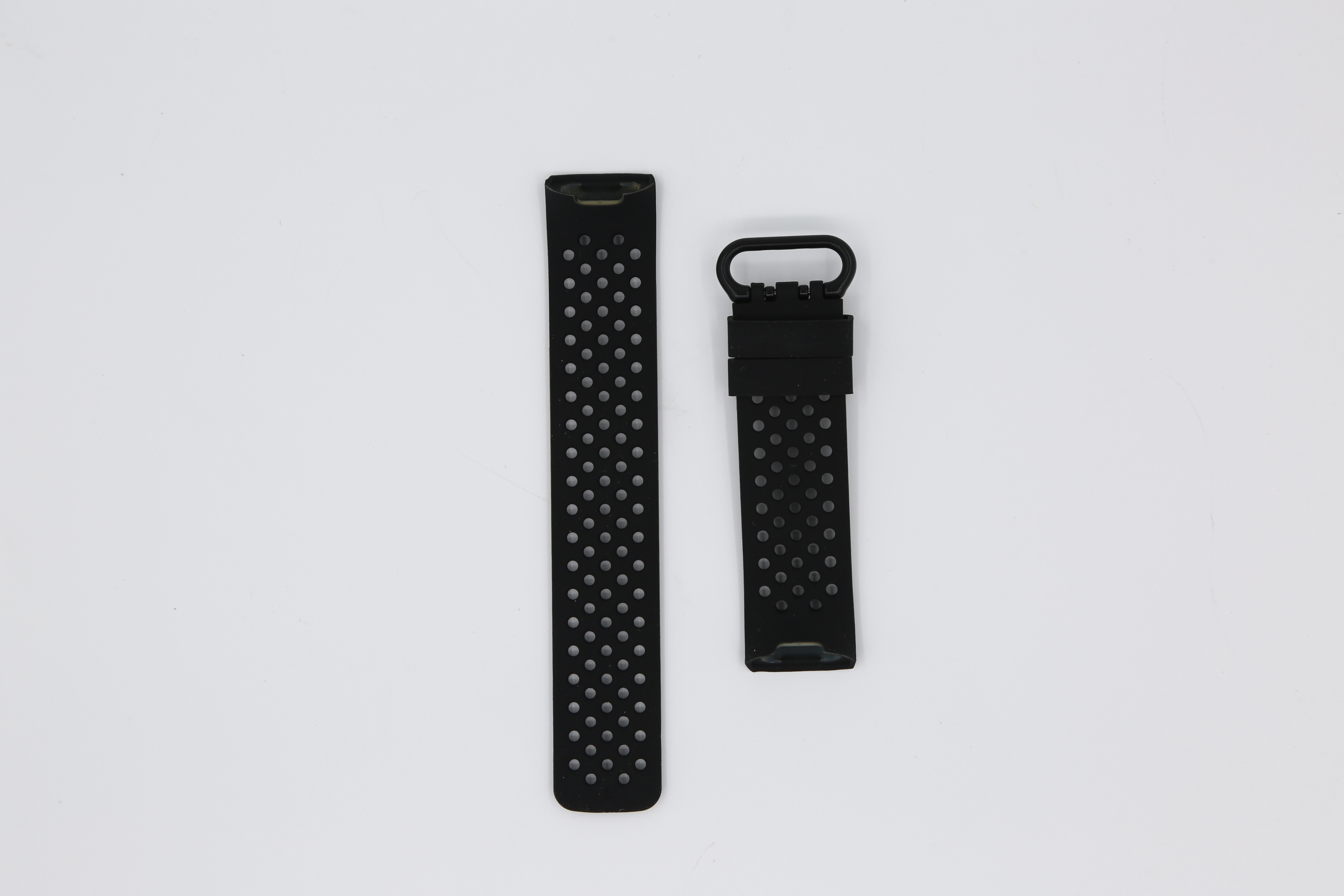 Deux bracelets de montre noirs. Un avec des trous, l'autre avec un fermoir.