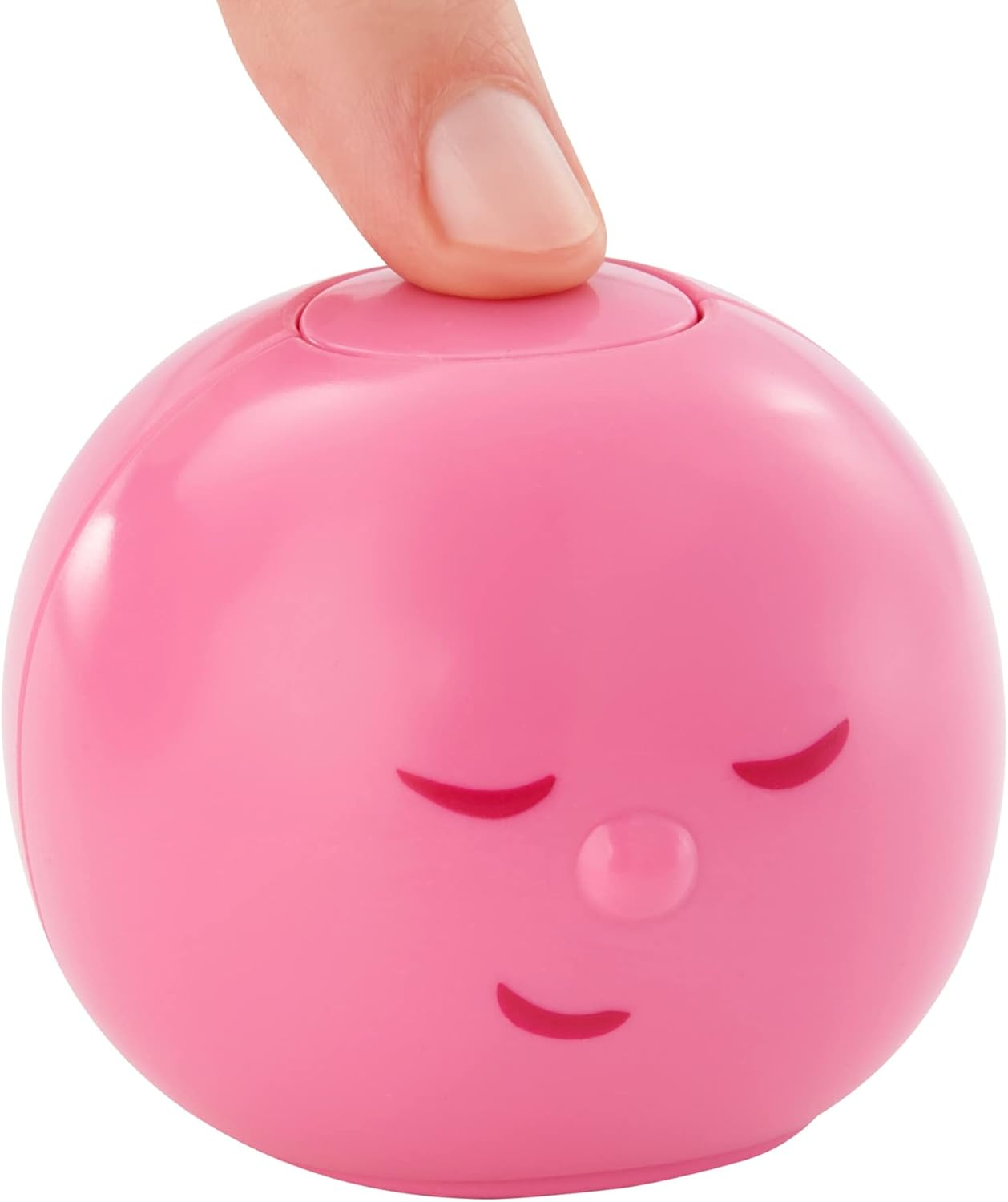 Ein rosa, rundes Spielzeug mit einem Gesicht, und ein Finger, der oben drückt.