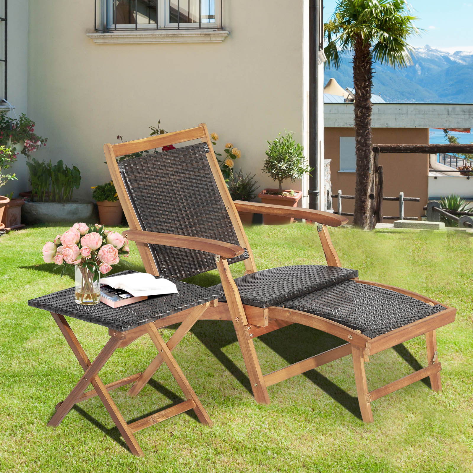 Holz-Liegestuhl und kleiner Tisch auf Rasen; Blumen und Haus im Hintergrund.