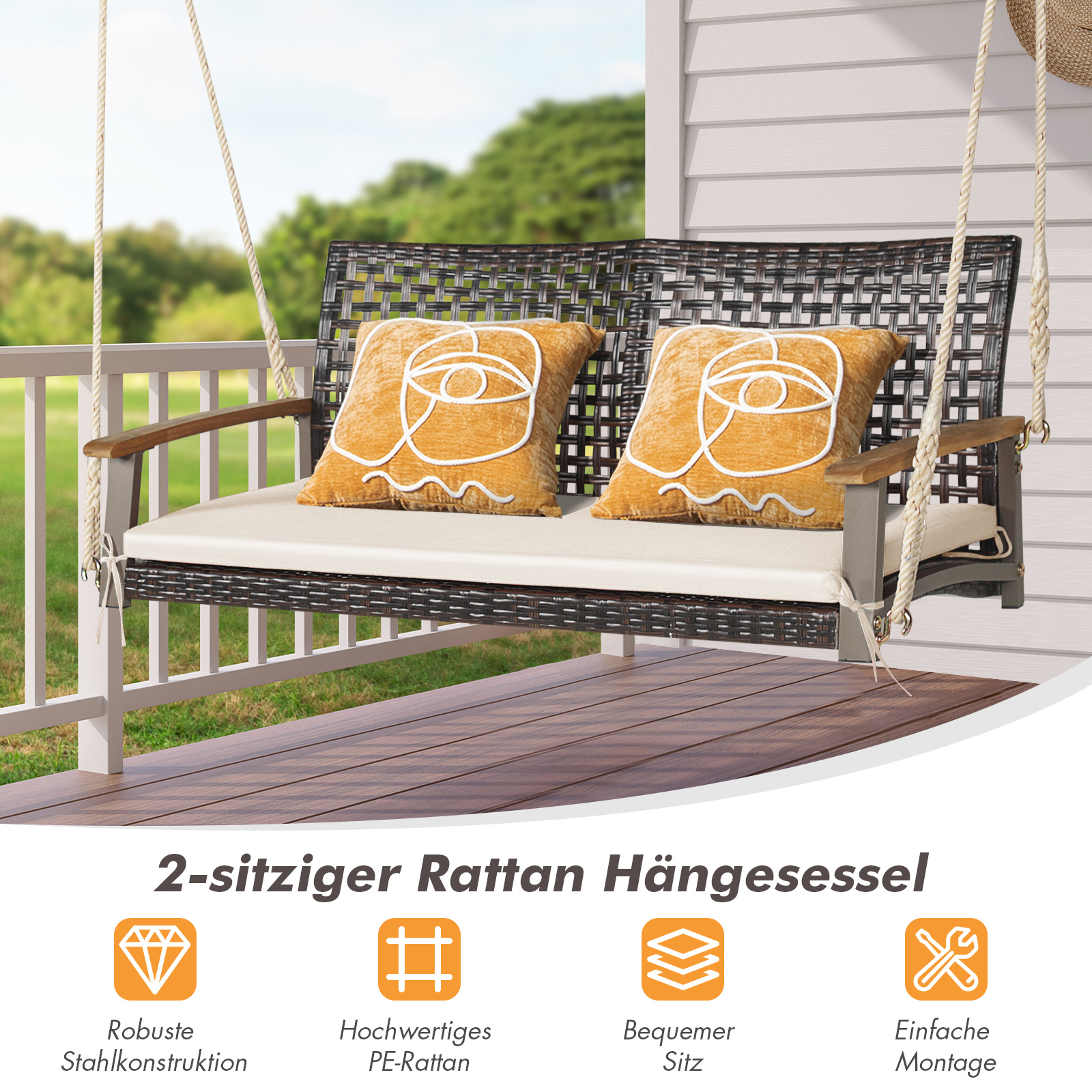 Rattanschaukel mit zwei Kissen, Holzarmlehnen und weißem Kissen auf einer Veranda.