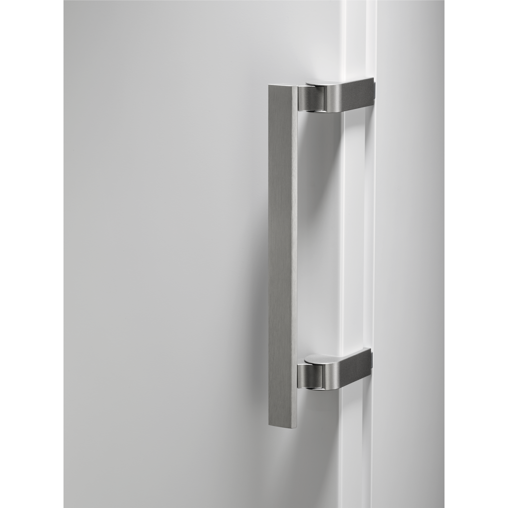 Un primer plano de una puerta blanca con un tirador plateado, sobre un fondo negro.