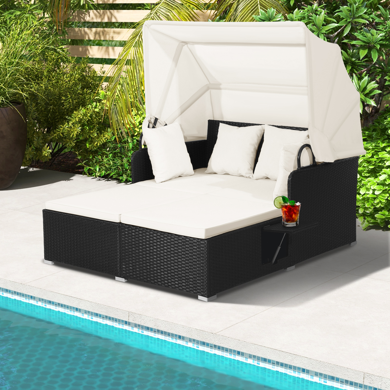 Schwarz-weißes Outdoor-Daybed mit Baldachin. Weiße Kissen, ein Beistelltisch mit Getränk.