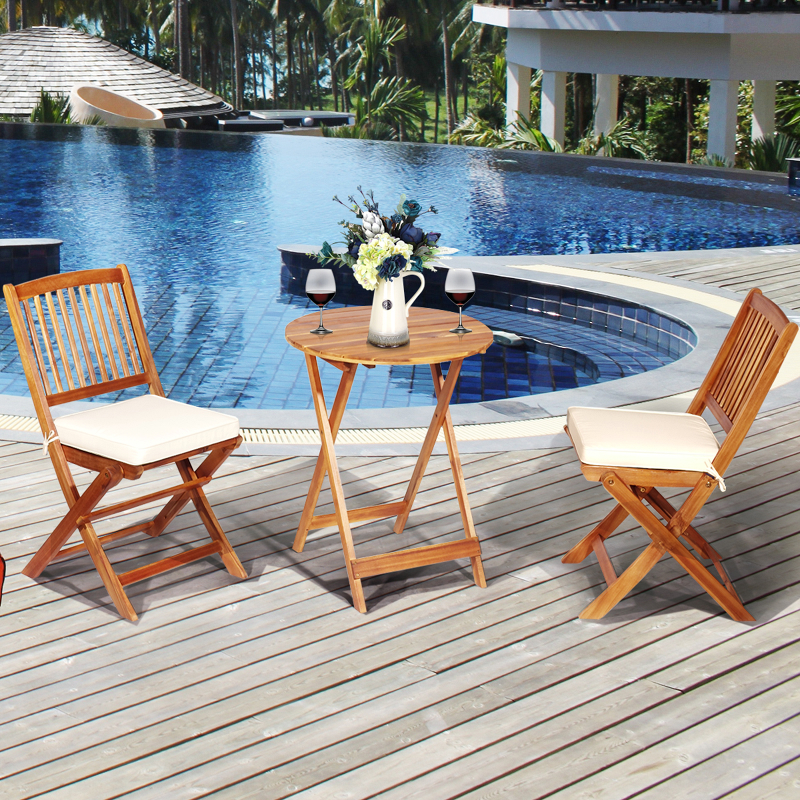 Holz-Terrassenmöbel mit zwei Stühlen, einem Tisch und zwei Weingläsern am Pool.