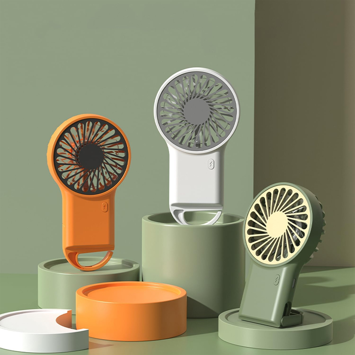 Drei tragbare Ventilatoren in Orange, Weiß und Grün. Jeder auf einem anderen Ständer. Grüner und weißer Hintergrund.