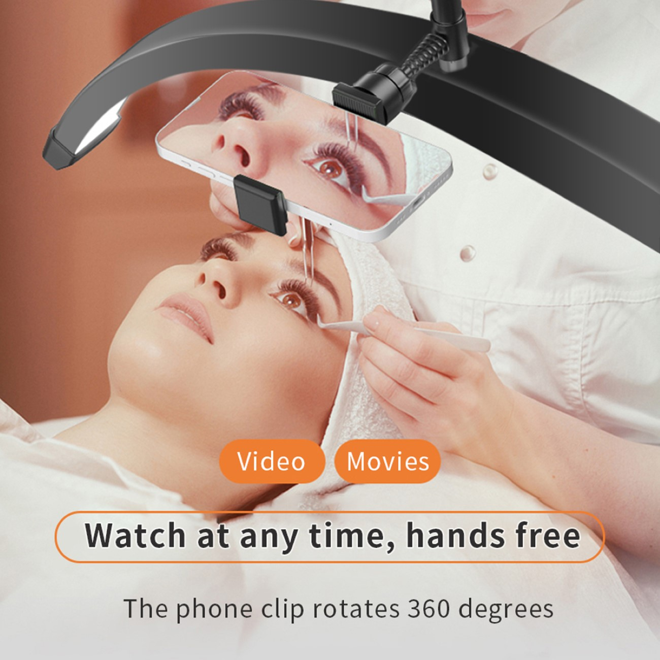 Eine Frau lässt sich die Wimpern bearbeiten. Ein Telefon ist über ihrem Gesicht montiert.
