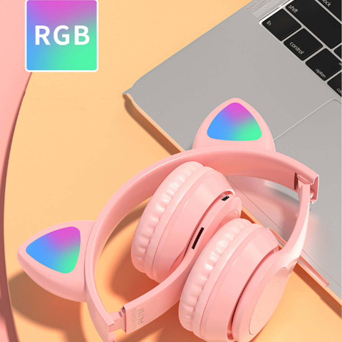 Rosa Katzenohr-Kopfhörer mit RGB-Lichtern, in der Nähe eines Laptops. Die Kopfhörer sind kabellos.