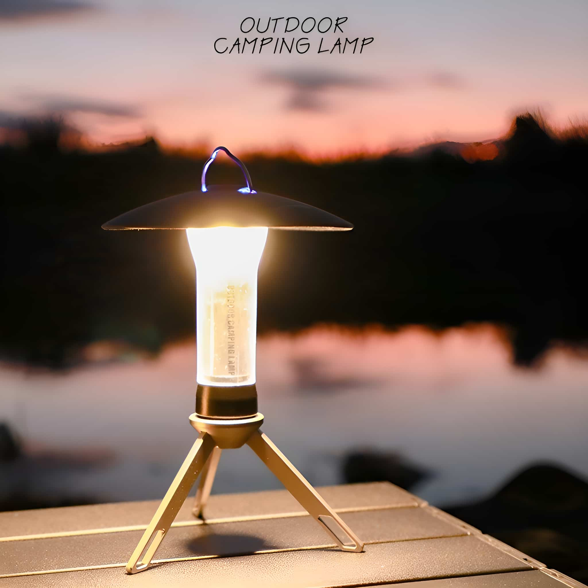 Eine Campinglampe für den Außenbereich mit einer leuchtenden Glühbirne auf einem Tisch. Sonnenuntergang im Hintergrund.