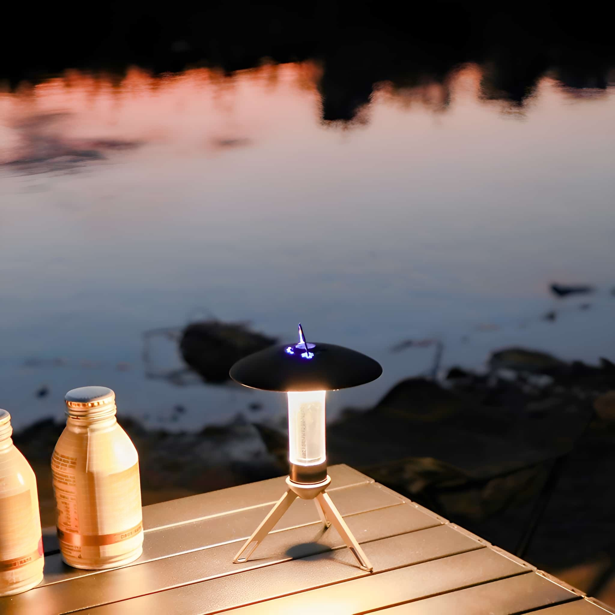 Eine kleine Lampe auf einem Stativ, auf einem Tisch mit zwei Flüssigkeitsflaschen, in der Nähe von Wasser.