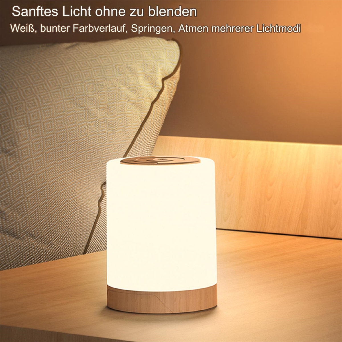 Eine zylindrische Lampe mit Holzsockel und -oberteil, die weiches Licht ausstrahlt. Dahinter liegt ein Kissen.